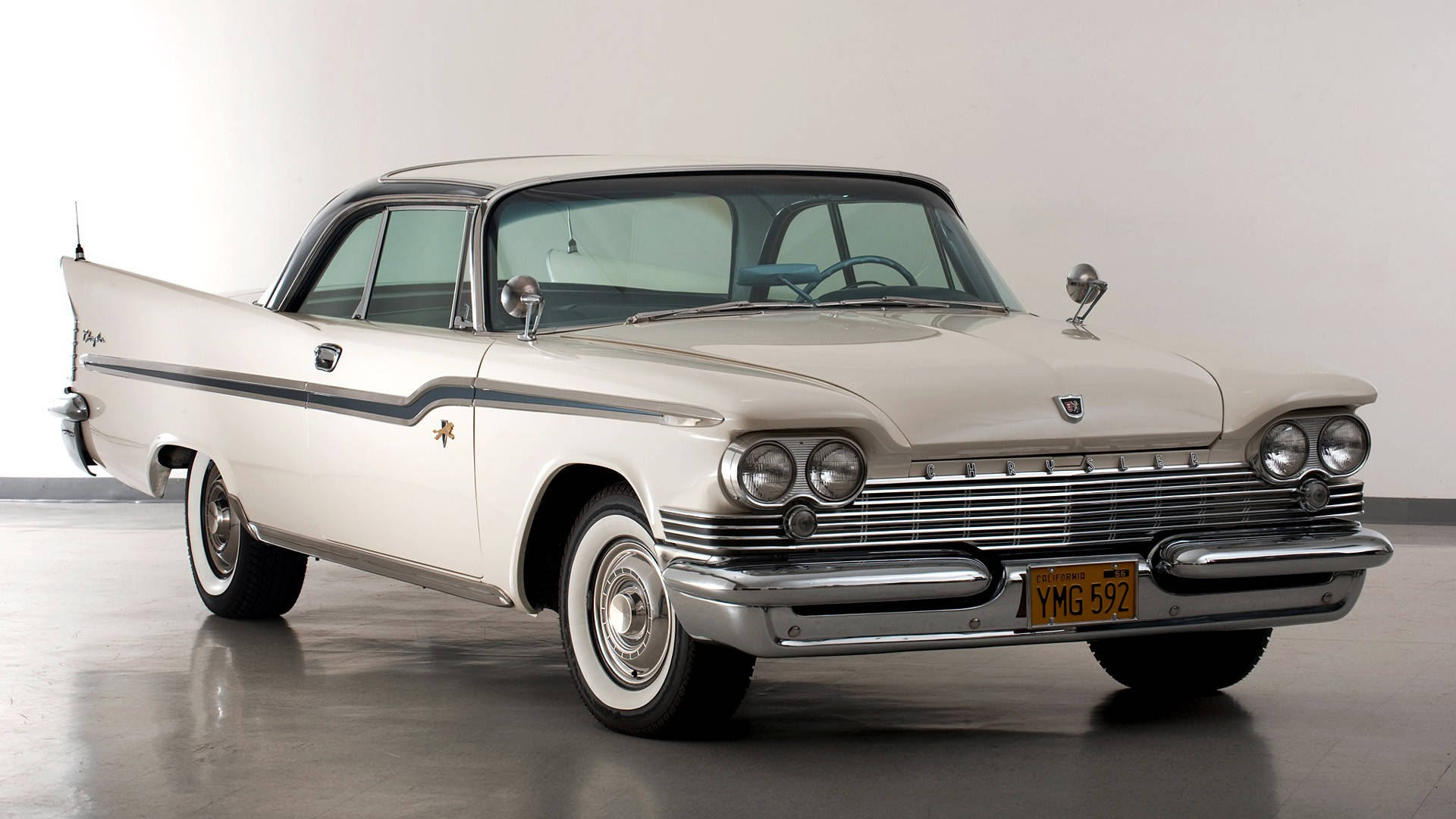 復古 Chrysler Windsor 壁紙 — 一輛帶有鍍鉻裝飾和尾鰭的純白色1950年代克萊斯勒，在拋光地板上的工作室燈光下閃閃發光。