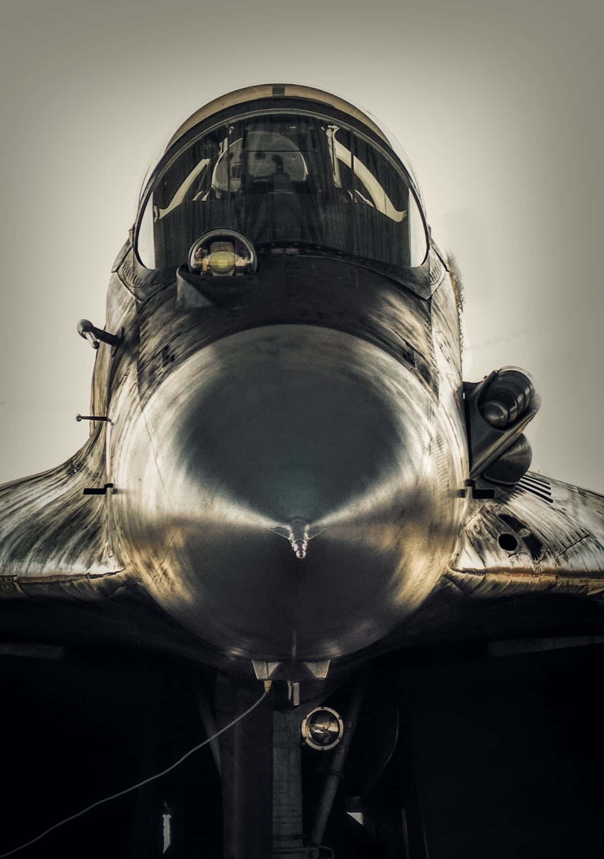 復古Dassault Rafale緊湊特寫Android巨無霸飛機背景 壁紙 — 戰鬥機機鼻錐和駕駛艙的特寫，帶有金屬光澤和戲劇性燈光。