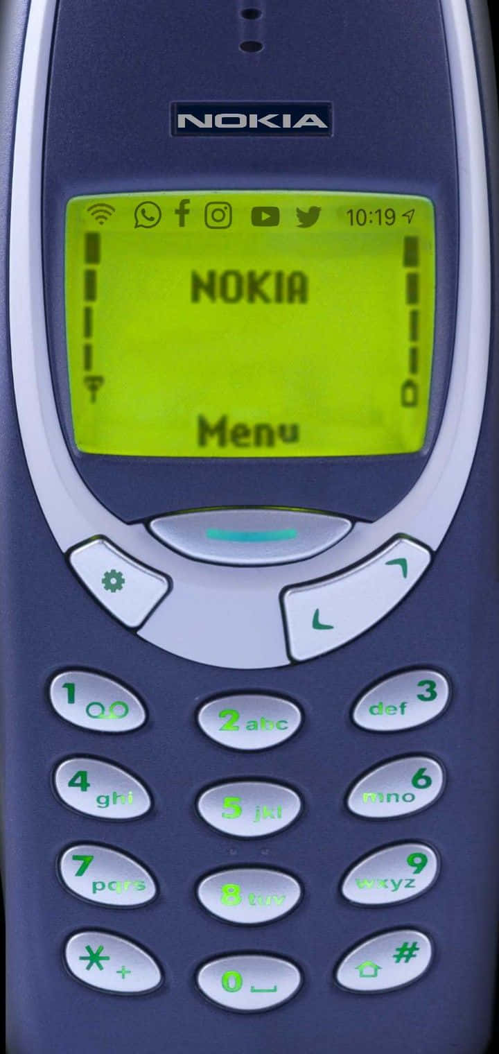 Nokia 桌布 壁紙 — 復古Nokia手機的特寫，帶有發光的綠色屏幕，顯示菜單和社交媒體圖標。