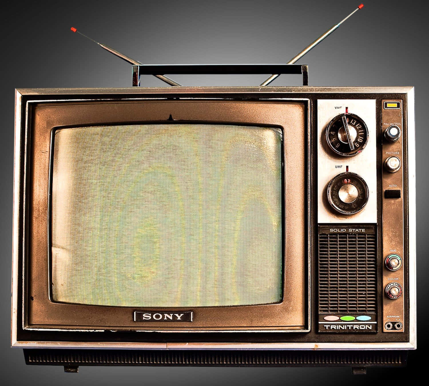 tv 桌布 壁紙 — 復古Sony Trinitron電視，帶天線和旋鈕，屏幕上顯示雪花，背景為深色漸變。