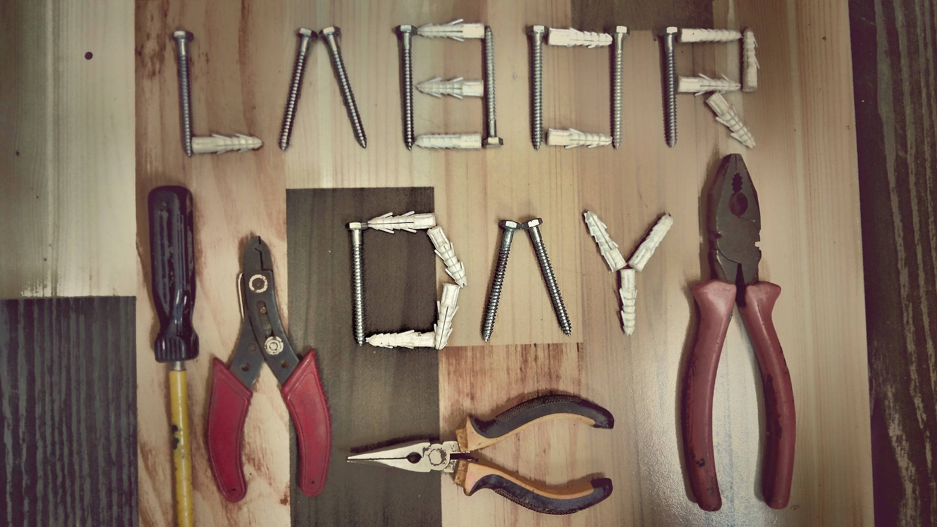工具排列成 Labor Day 喺木頭上