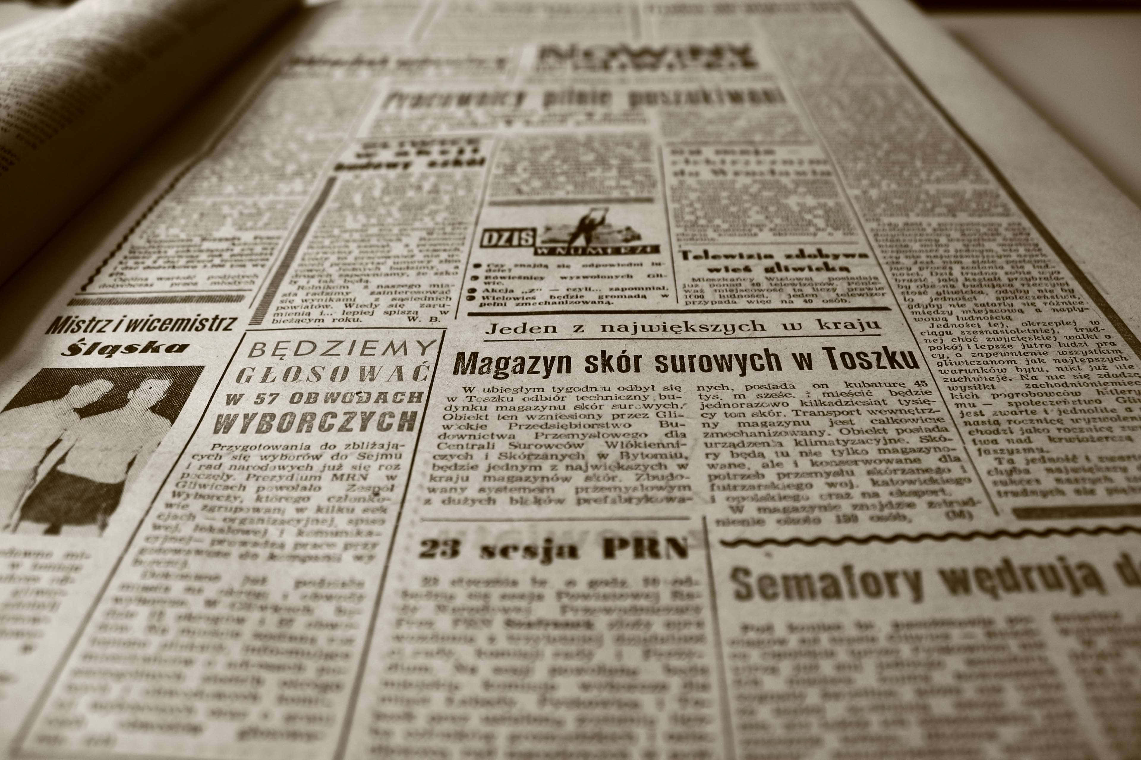 Journalism 桌布 壁紙 — 復古波蘭報紙頁面的特寫，帶有粗體標題和密集文字，在溫暖燈光下。