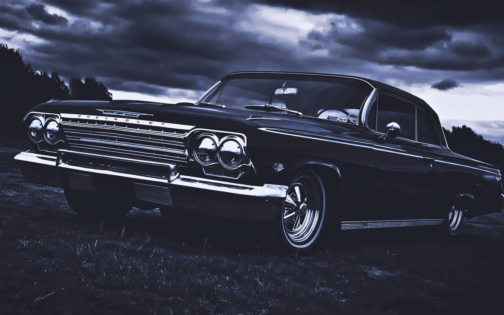 復古美學雪佛蘭Impala 1967 壁紙 — 一輛時尚的黑色經典雪佛蘭轎車在充滿戲劇性雲彩的暮色天空下閃閃發光。