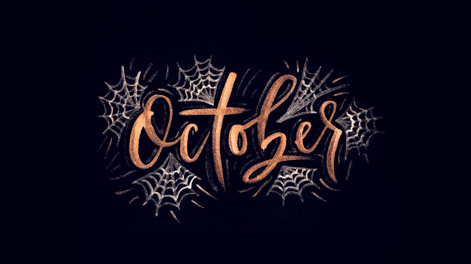 October 以銅色字體書寫，配上銀色蜘蛛網喺深色背景上。
