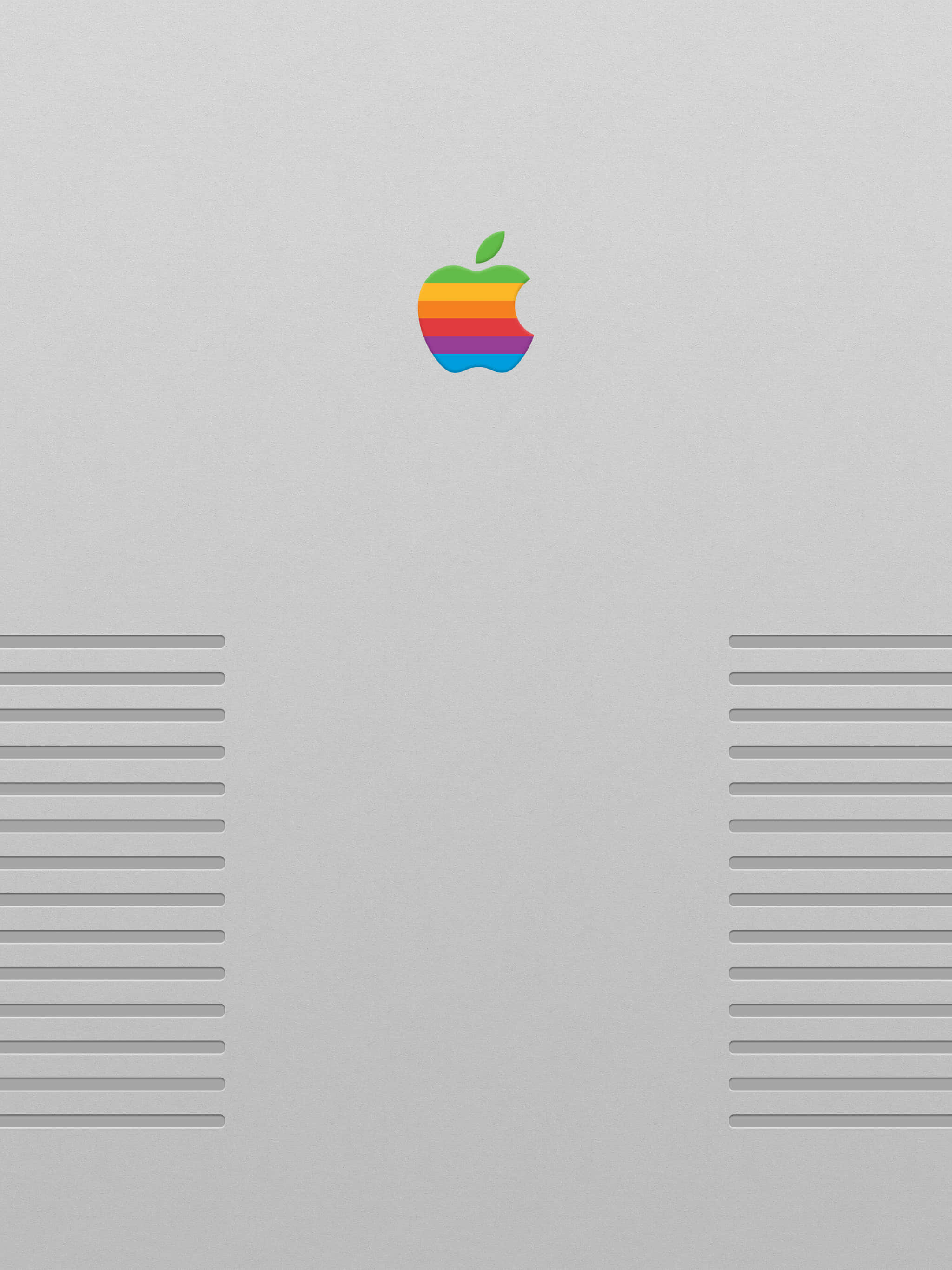 復古蘋果標誌 壁紙 — 復古彩虹Apple標誌居中於銀色電腦機箱上，兩側有對稱的通風條。