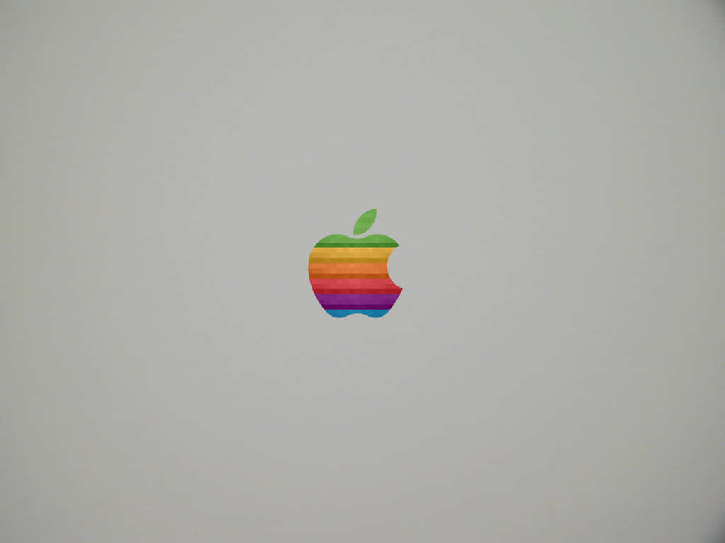 復古蘋果標誌 壁紙 — 一個復古彩虹Apple標誌，位於純淺灰色筆記本電腦蓋中央。