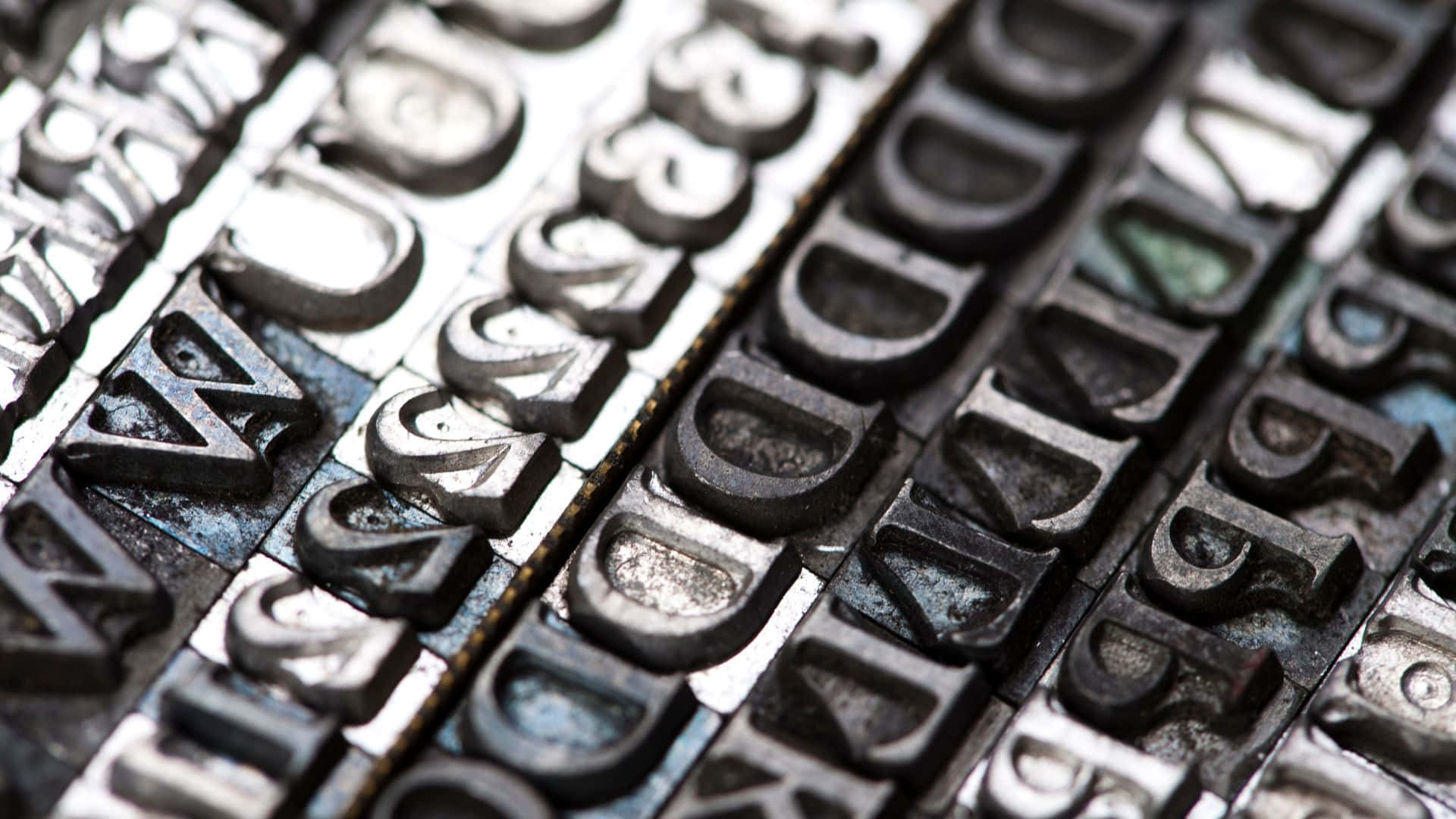 Typography 桌布 壁紙 — 復古金屬活字塊的特寫，帶有磨損的墨漬和金屬光澤。