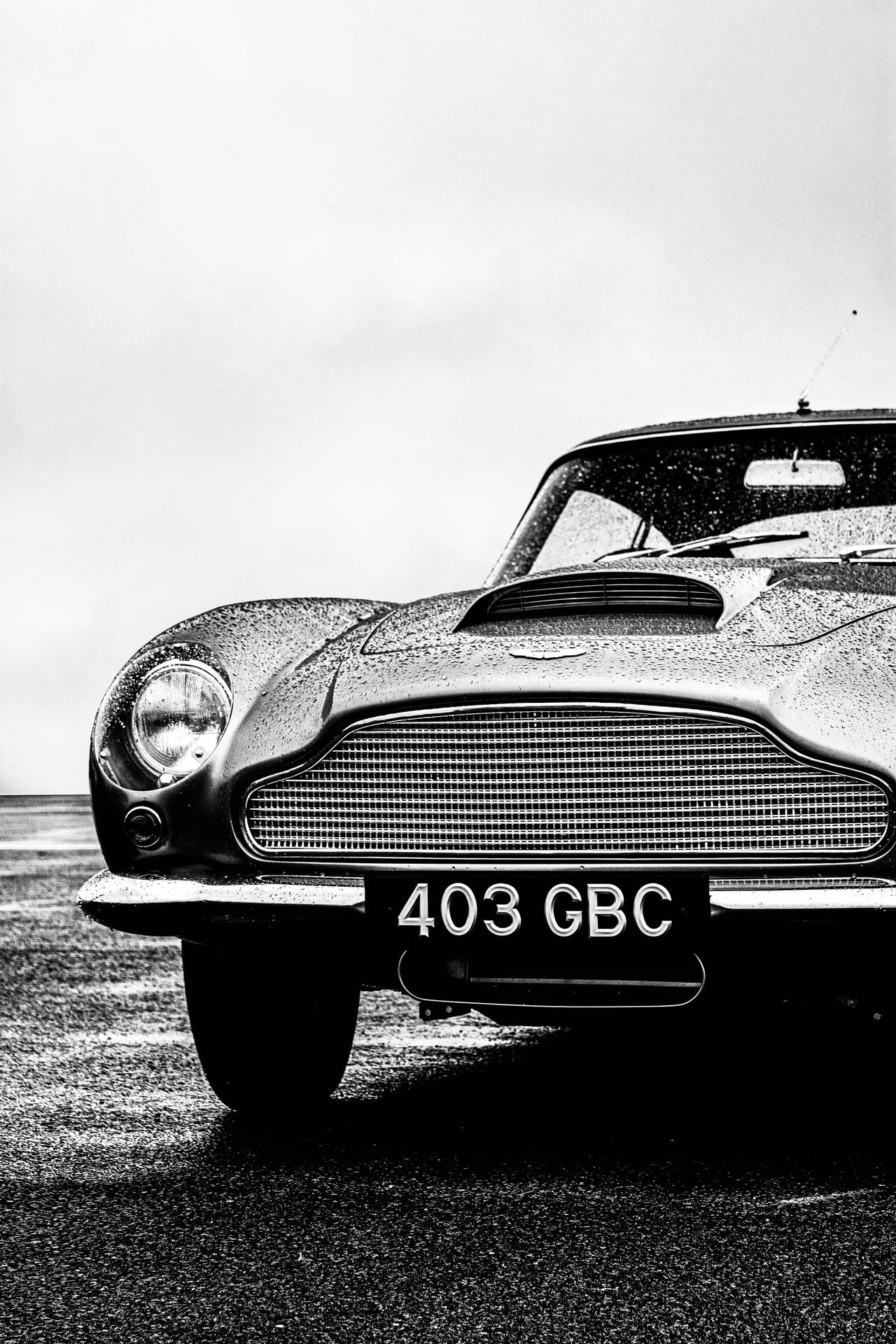經典 Aston Martin，引擎蓋和格柵上有雨滴。