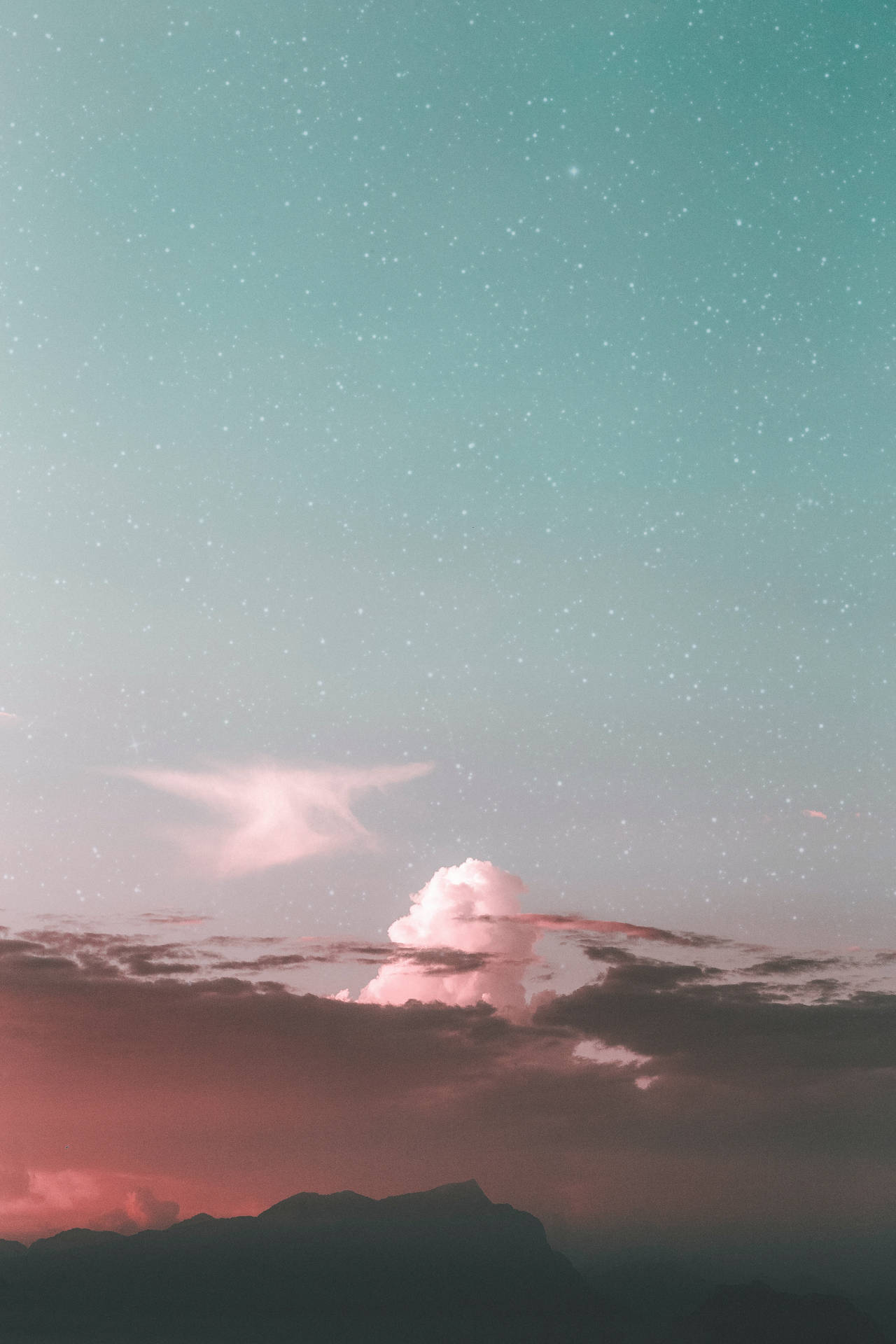 粉紅色和藍綠色的天空，星星和雲朵在黃昏時的山脈輪廓之上。