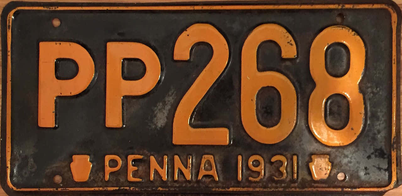 復古黑橙車牌 壁紙 — 1931年賓夕法尼亞州復古車牌，黑色金屬上帶橙色字體，顯示磨損和鏽跡。