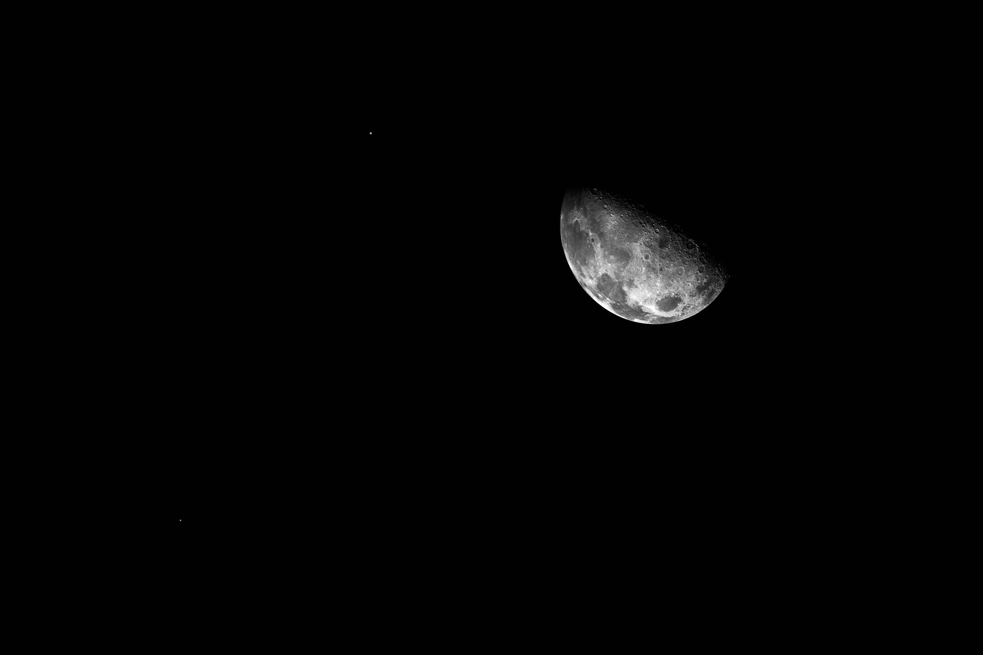 黑暗夜空中的彎月與微弱的星星