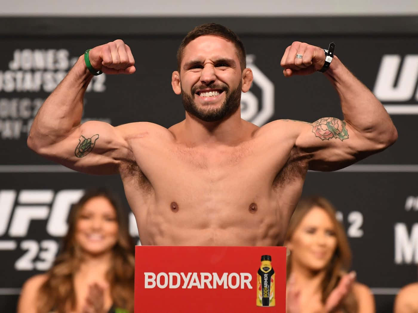 UFC拳手在稱重活動中彎曲手臂，帶有BodyArmor標誌。