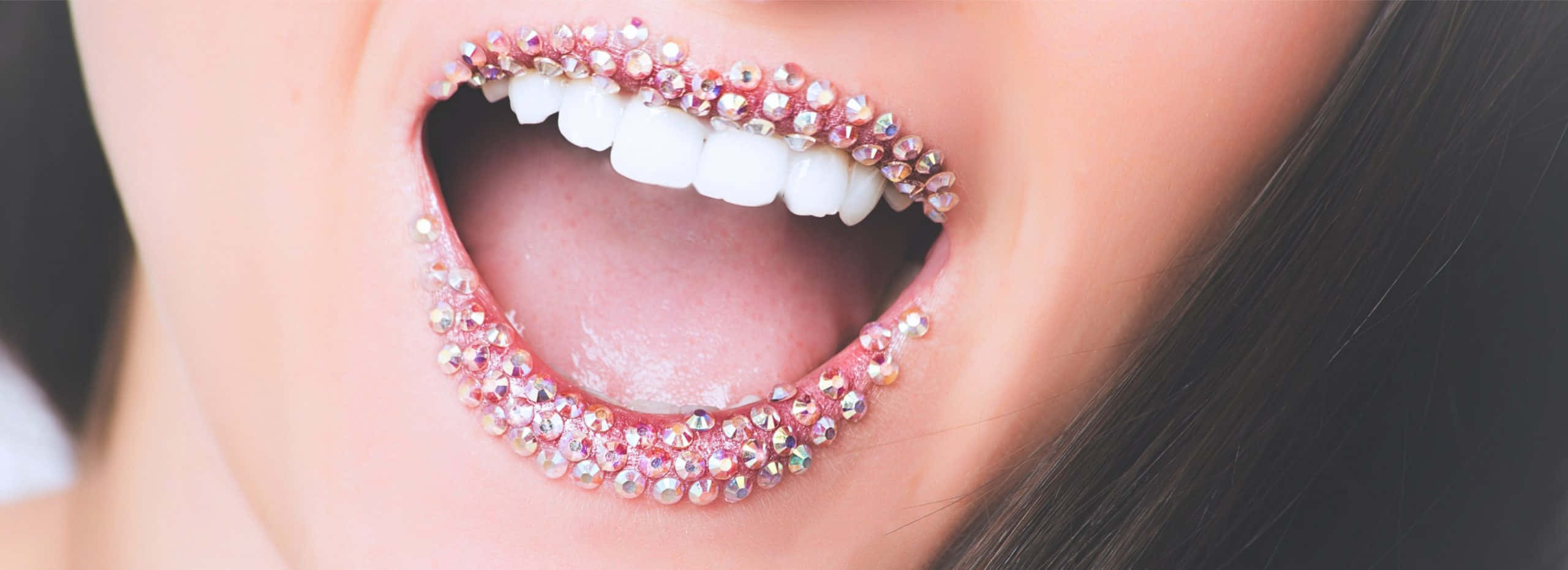 Teeth Whitening 桌布 壁紙 — 微笑嘴唇的特寫，沿著嘴唇和牙齒飾有閃閃發光的粉紅色水鑽。