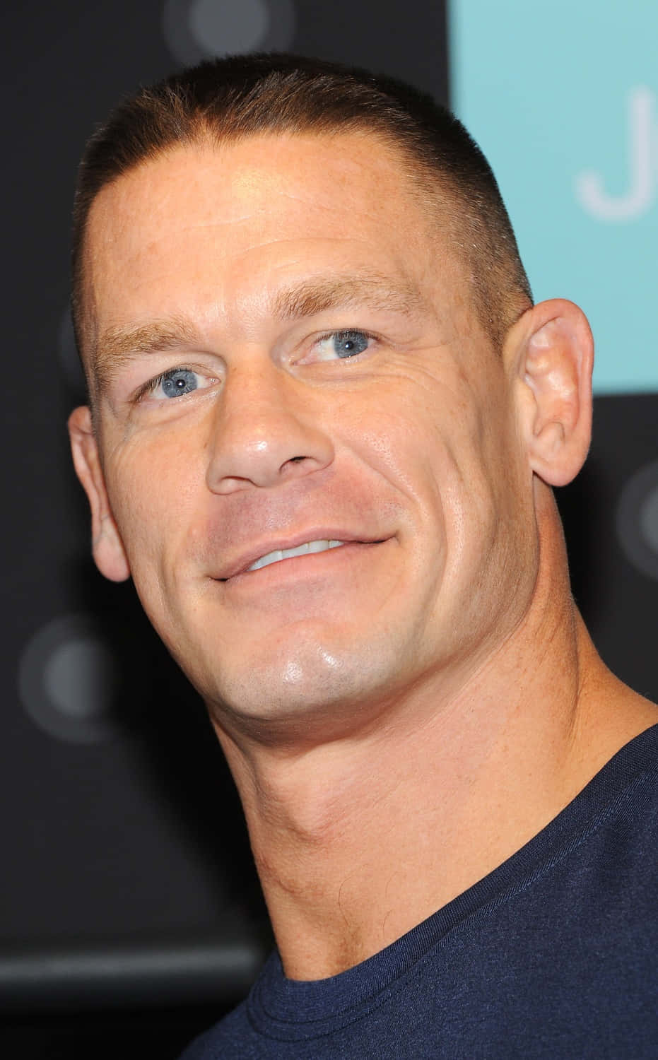 John Cena 桌布 壁紙 — 微笑男士的頭像特寫，短黑髮、藍眼睛，身穿深藍色T恤。