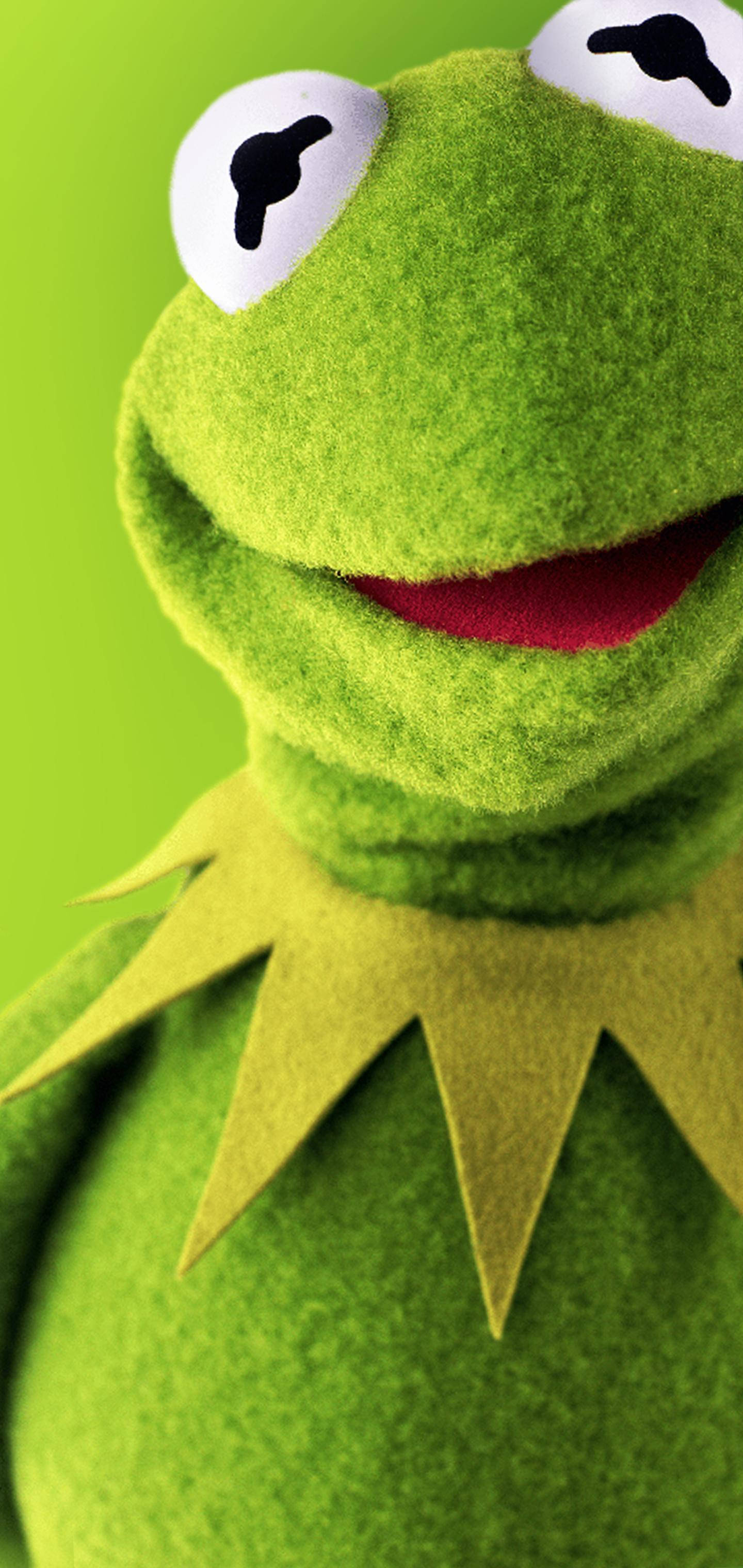 微笑的Kermit青蛙 壁紙 — Kermit the Frog 開心面孔的特寫，帶有亮綠色氈質感和大眼睛，背景為純綠色。