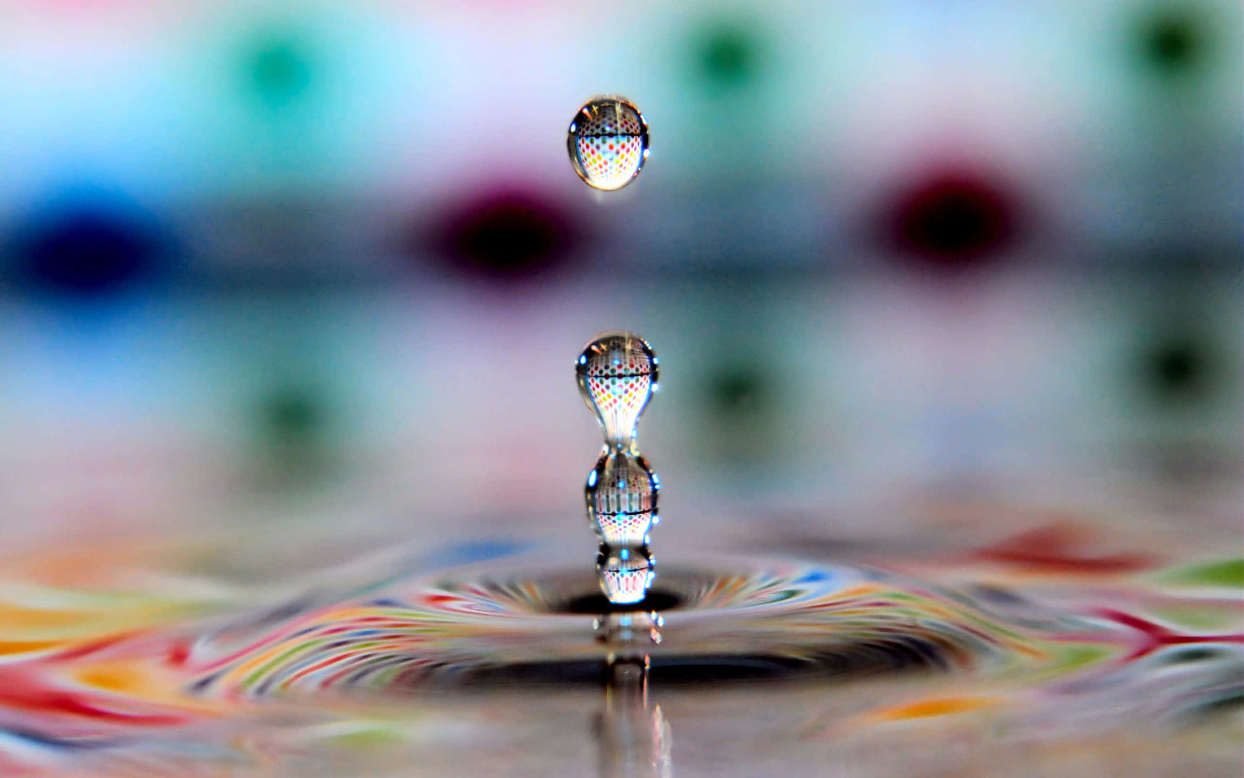 3d Water 桌布 壁紙 — 微距拍攝中，懸浮的水滴捕捉到色彩斑斕的漣漪表面上的彩虹倒影。