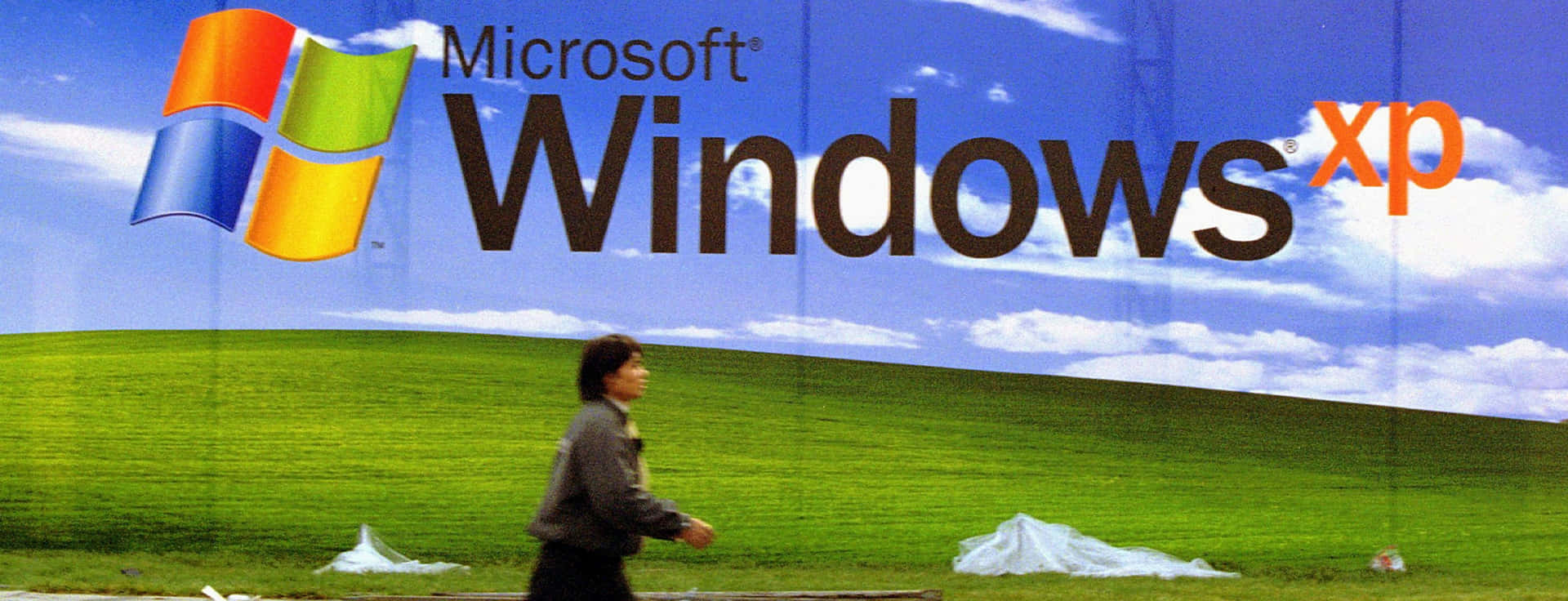 人走過一個大型 Windows XP 廣告牌。