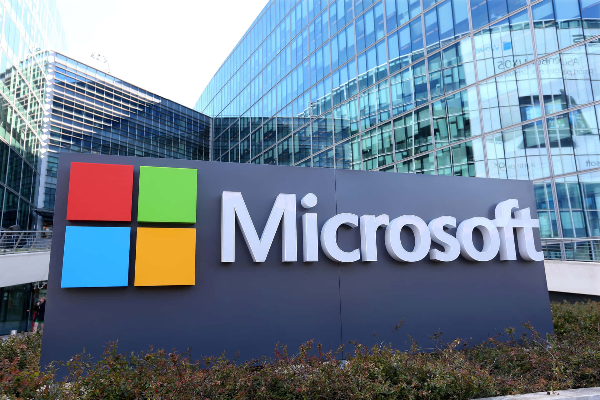 Microsoft公司標誌牌，帶有彩色標誌，位於玻璃辦公樓前。