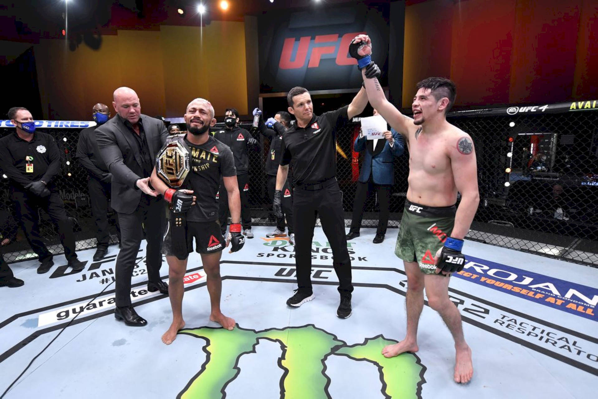 UFC拳手在八角籠中慶祝勝利，裁判舉起勝者的手，冠軍持有冠軍腰帶。