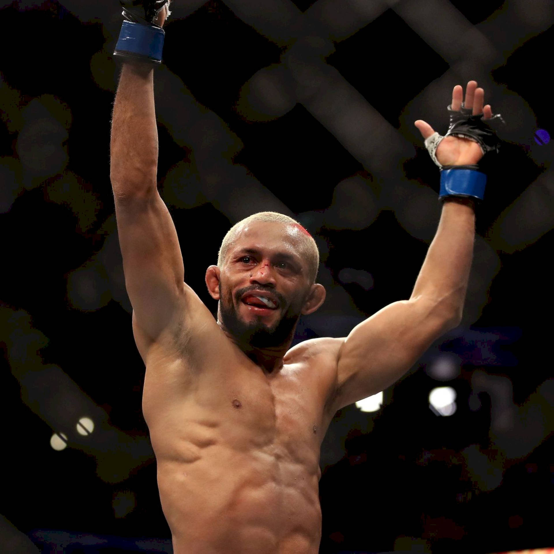 一位勝利的MMA選手在八角籠中高舉雙臂慶祝勝利。