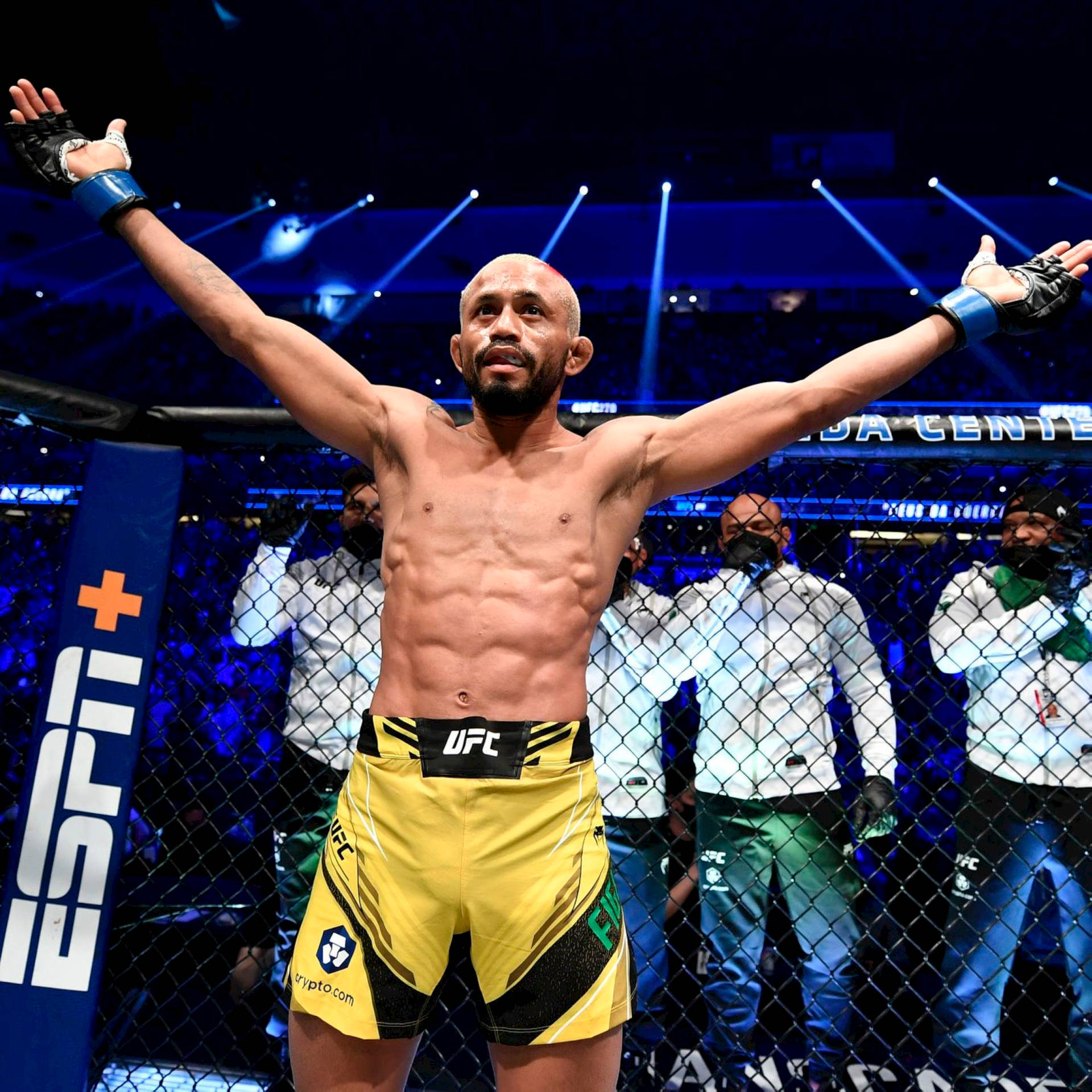 UFC拳手在八角籠內高舉雙臂慶祝勝利。