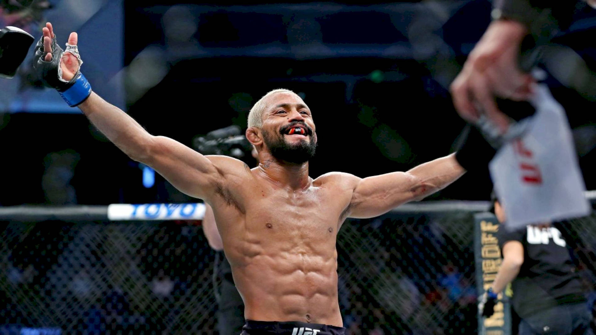UFC拳手在八角籠內舉起雙臂慶祝勝利。