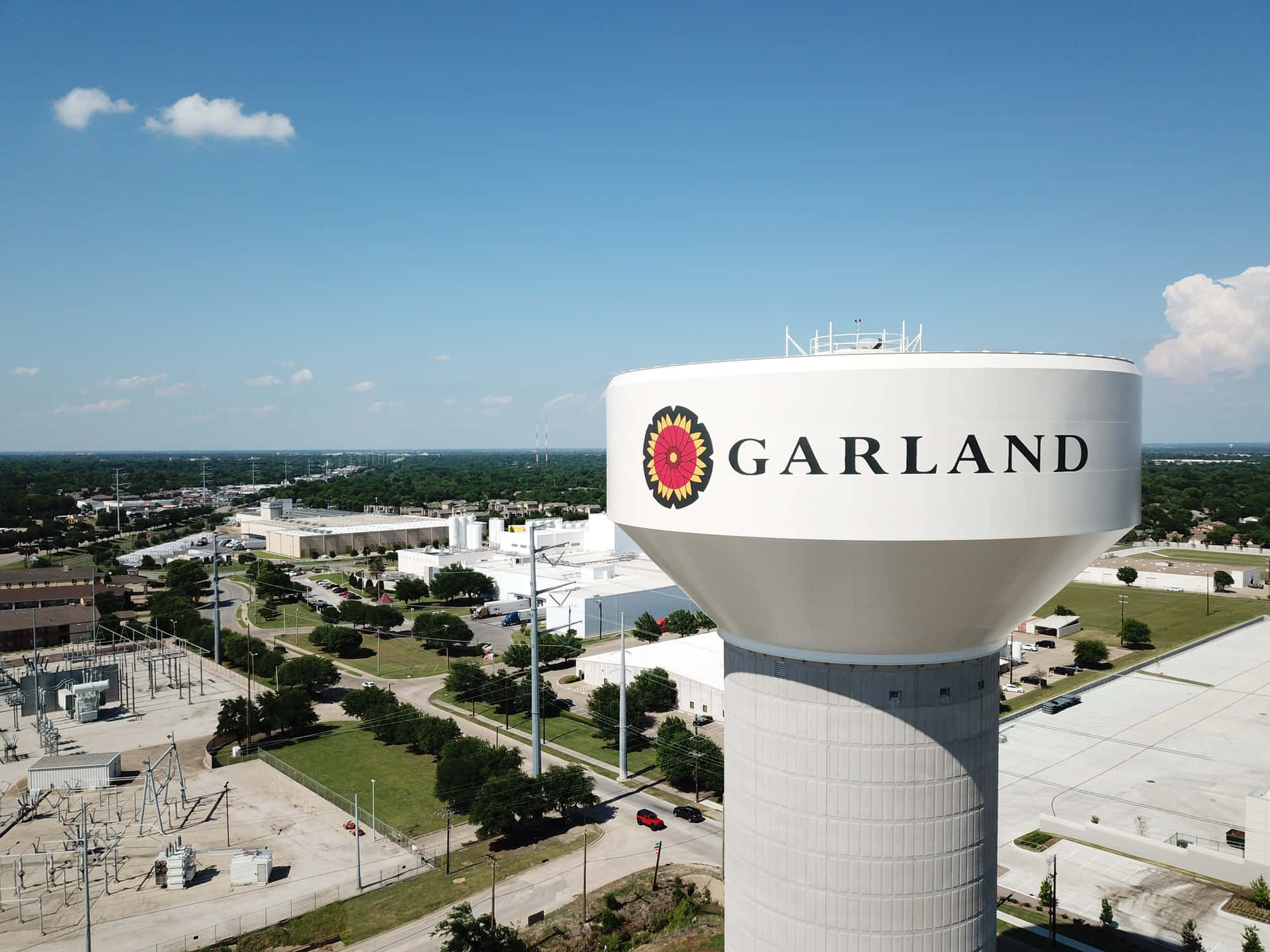 藍天下郊區的白色水塔，帶有Garland標誌和向日葵徽章。