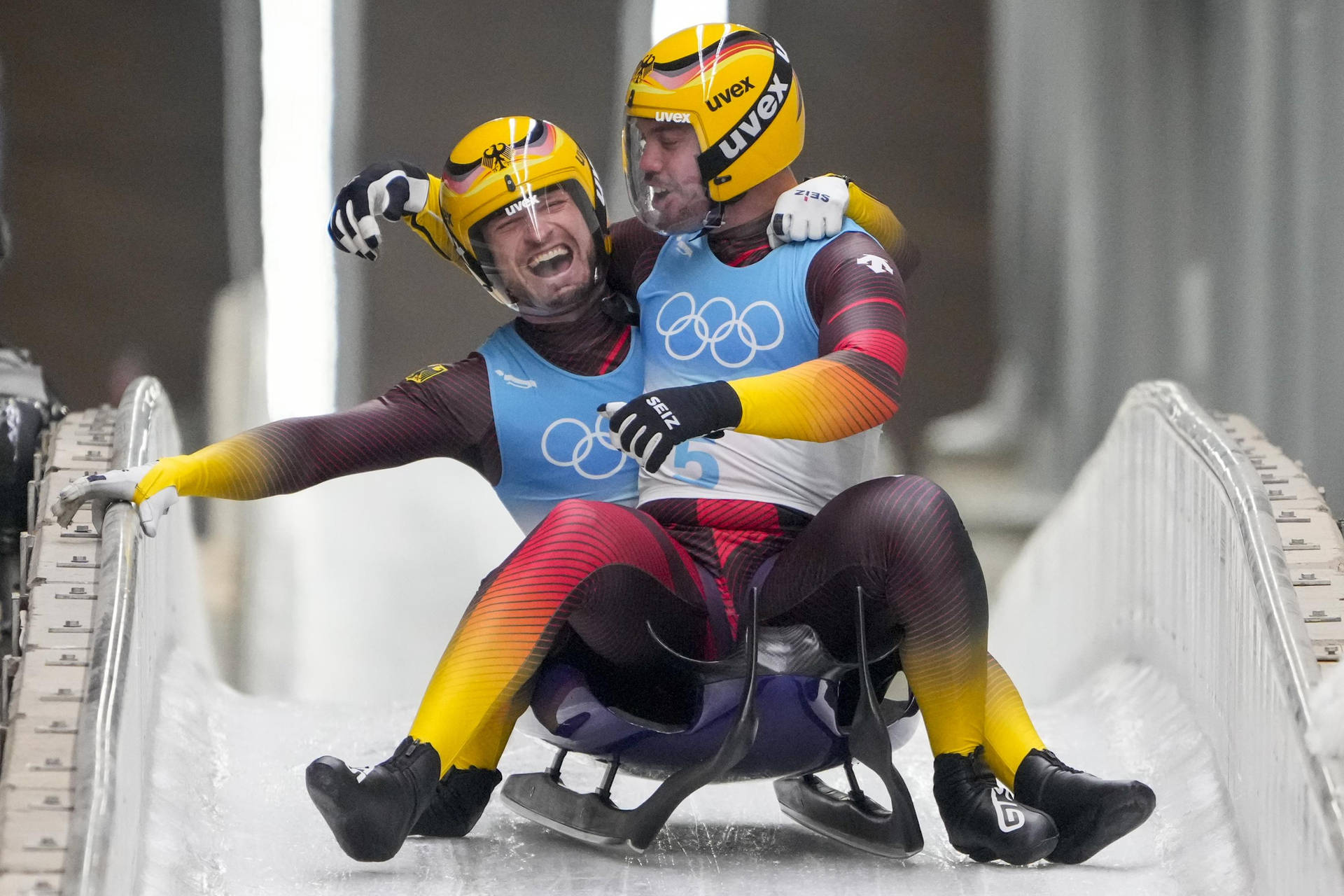 兩名雪橇運動員喺奧運期間喺冰道上慶祝勝利。