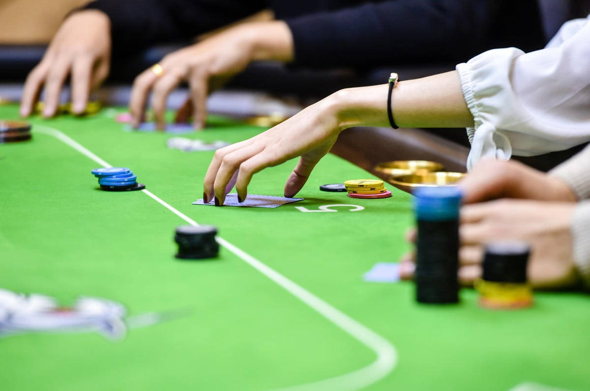 玩家在綠色氈桌上用籌碼和紙牌進行撲克遊戲。
