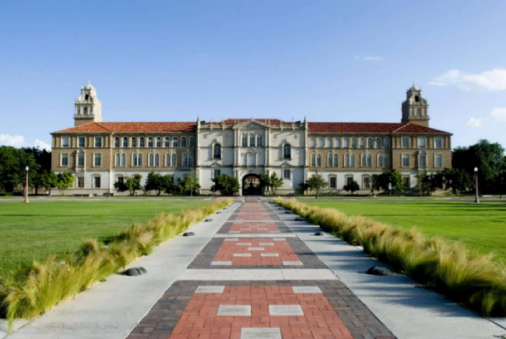 宏偉的大學建築，紅色屋頂和磚砌步道通往入口。