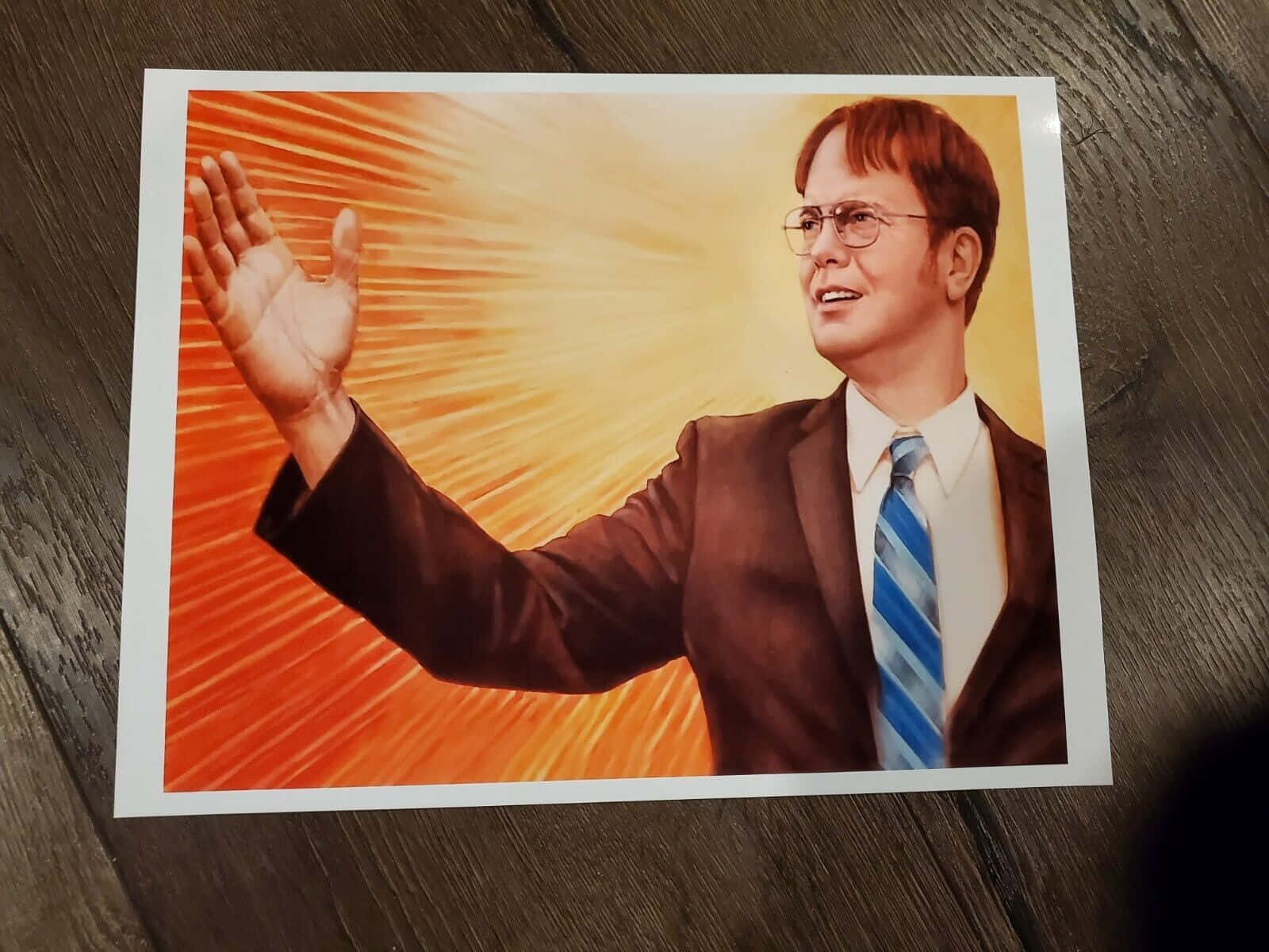 Dwight Schrute在木桌上以燦爛橙色背景揮手的肖像。