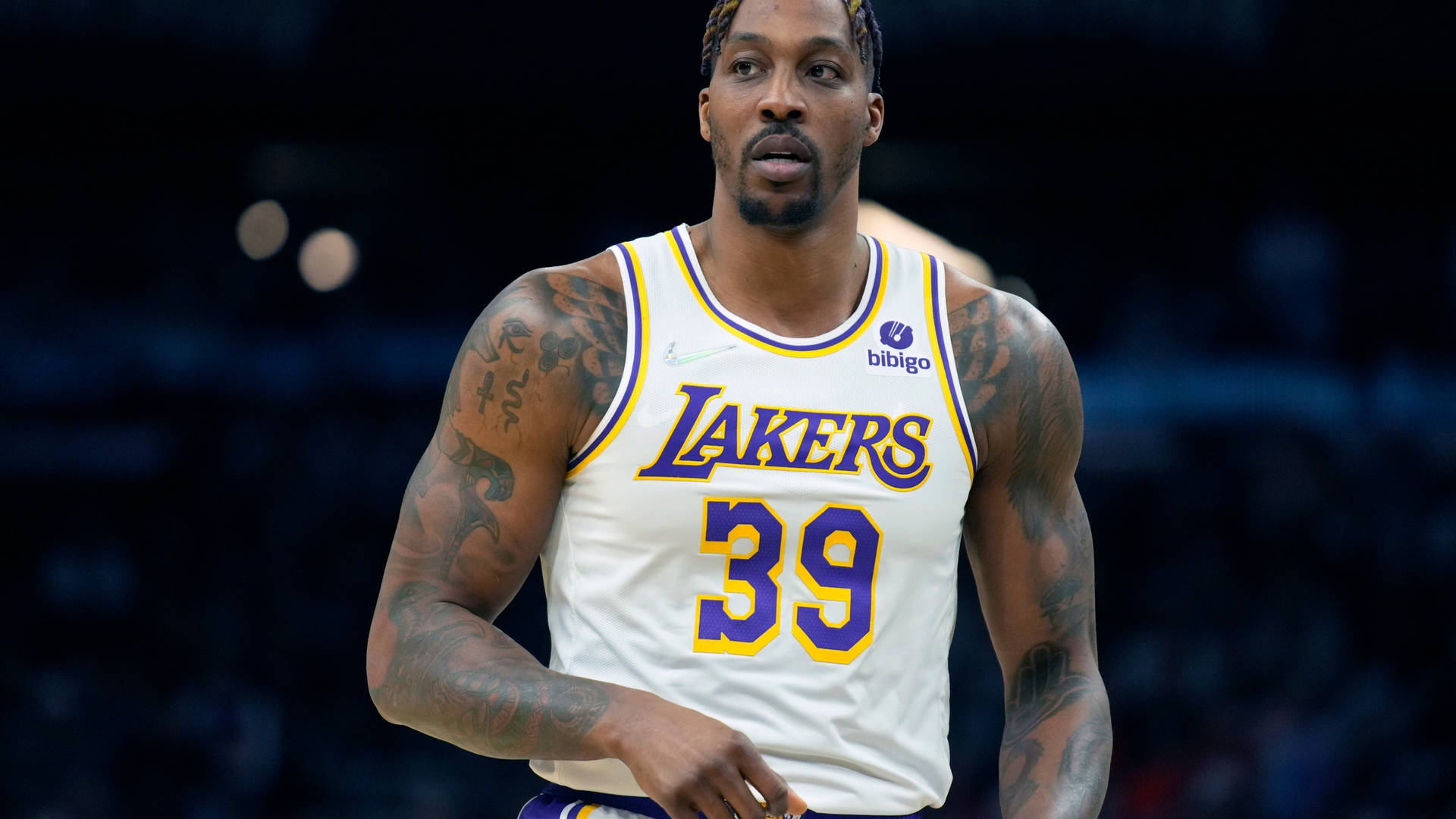 德懷特·霍華德 NBA 洛杉磯湖人隊籃球攝影 壁紙 — 一位專注的籃球運動員身穿白色湖人隊39號球衣，站在球場上，手臂上的紋身清晰可見。