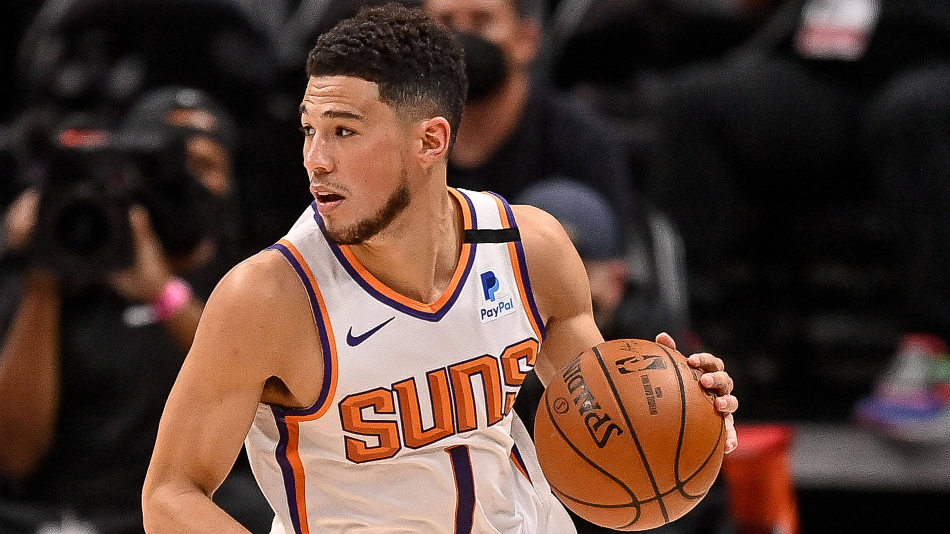 職業籃球運動員穿著Suns球衣在比賽中運球。