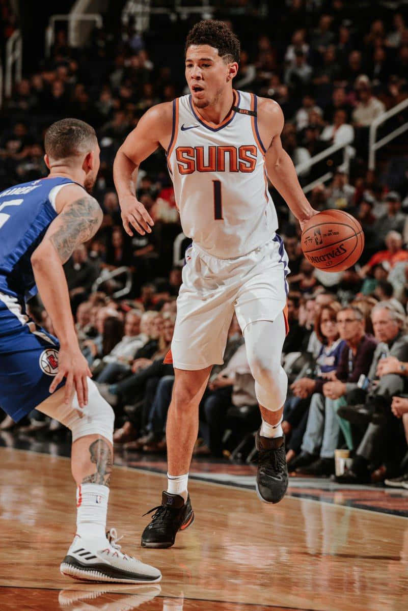 德文·布克籃球iPhone壁紙 壁紙 — 鳳凰城太陽隊球員在激烈的NBA比賽中運球，同時被快艇隊球員防守。