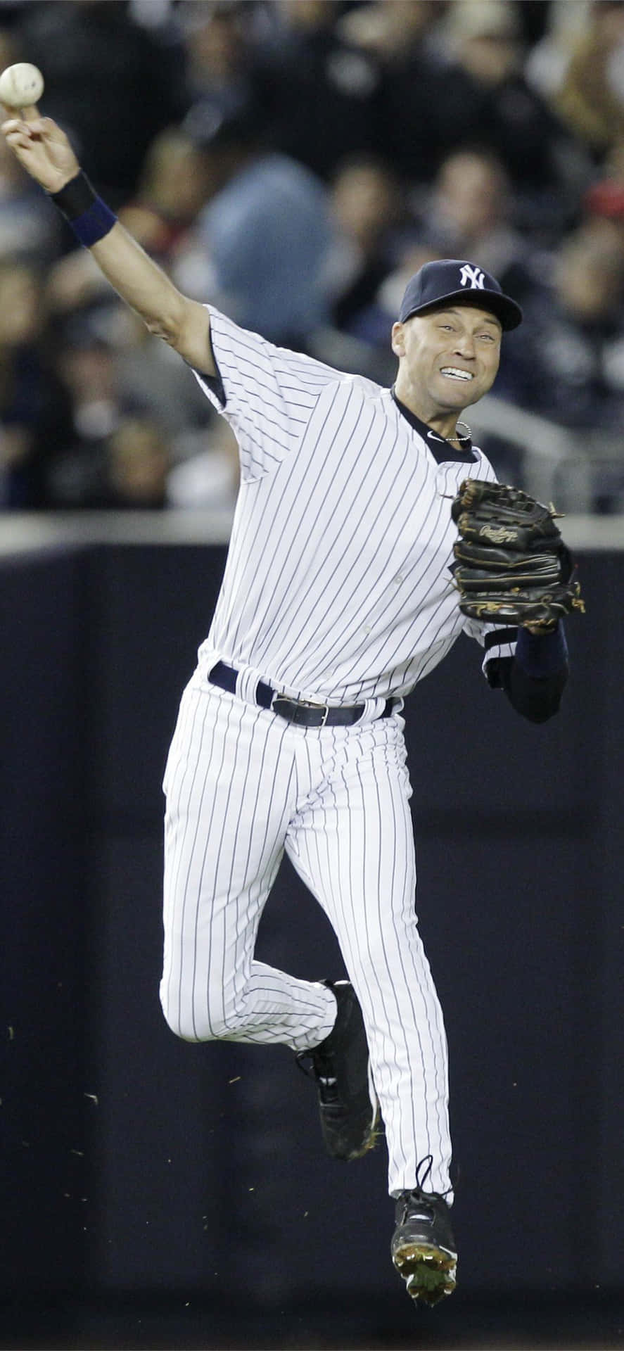 身穿細條紋球衣的棒球選手在夜間比賽中跳起投球。