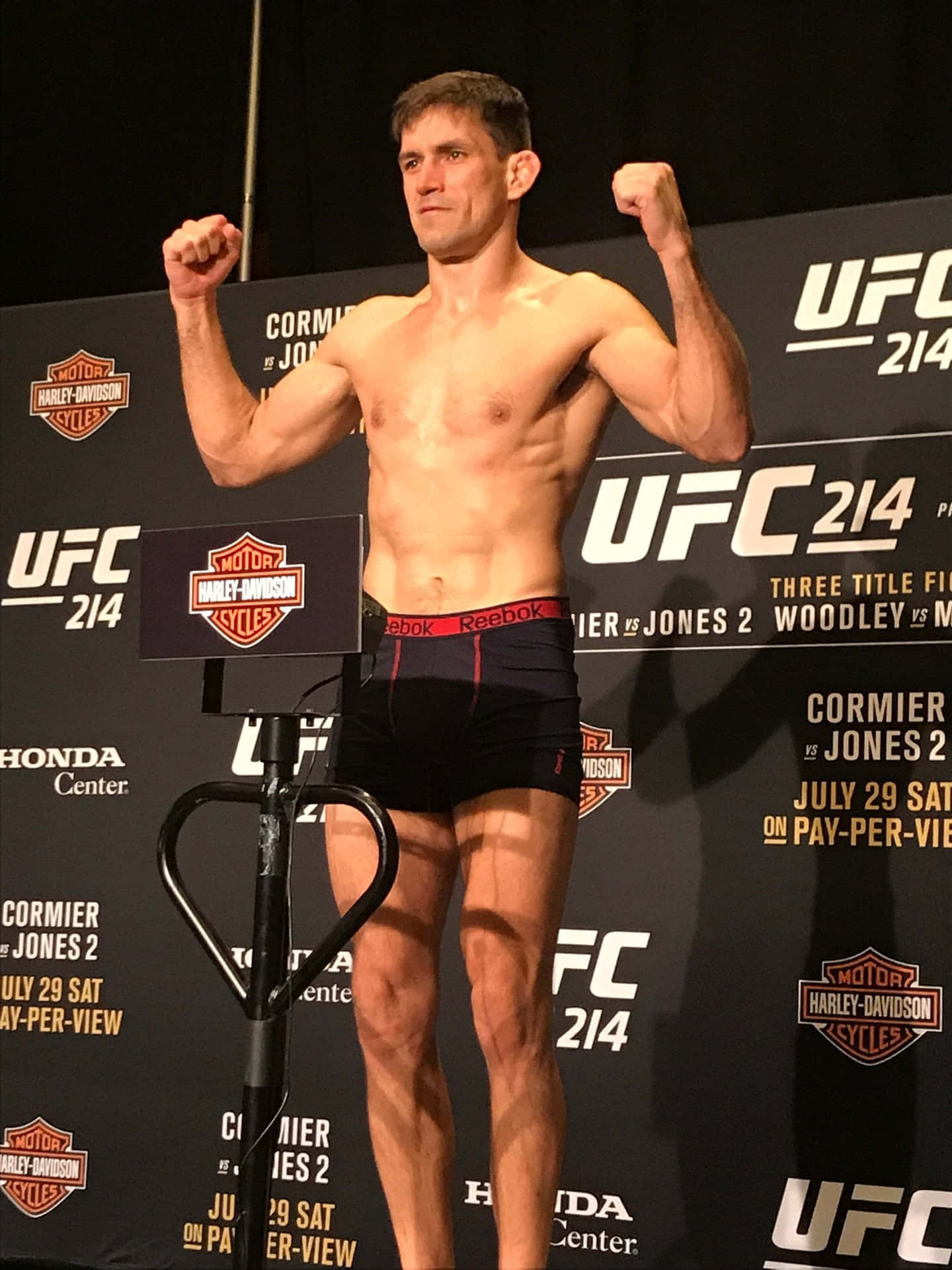 UFC拳手在稱重活動中在磅秤上彎曲二頭肌。