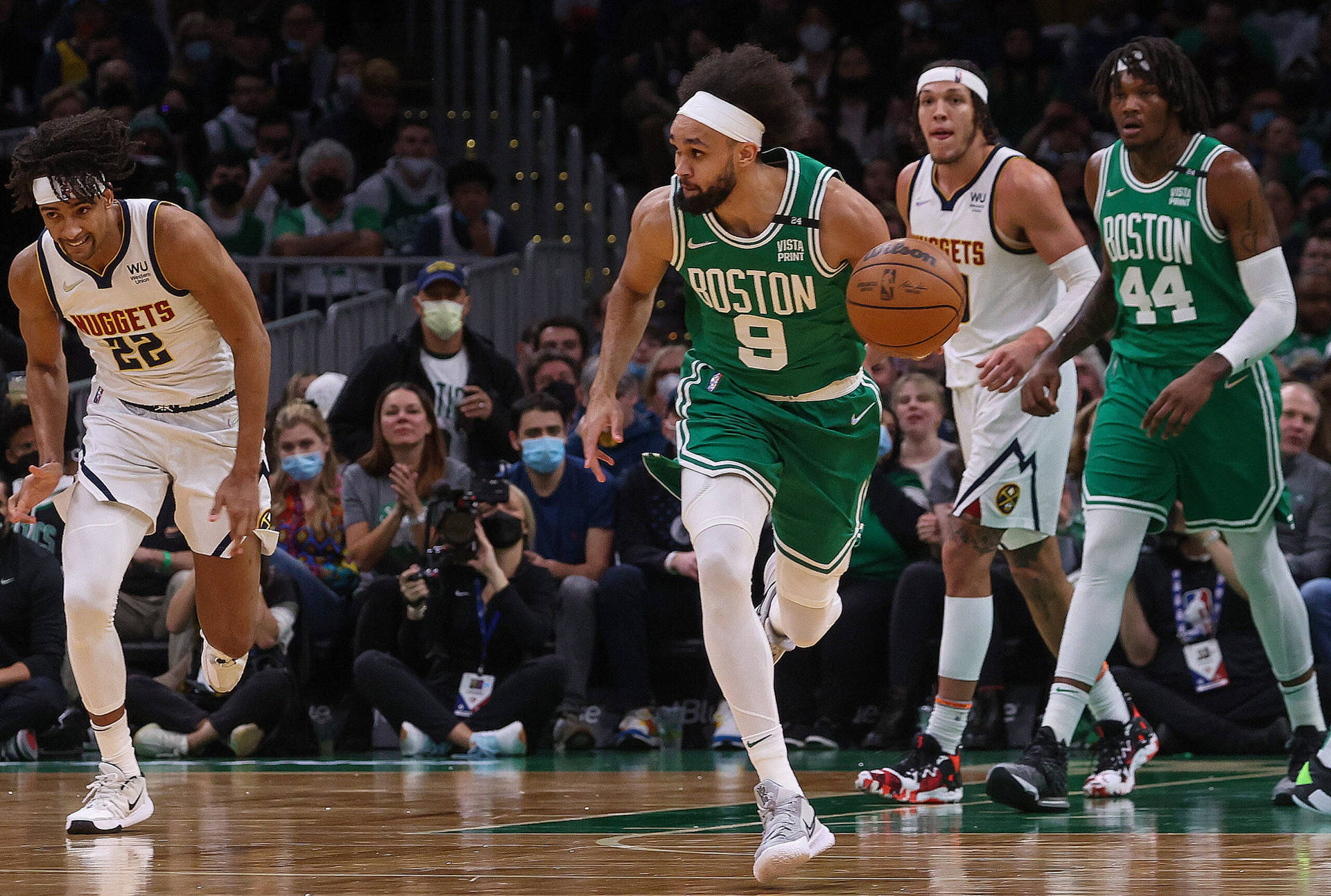 德里克·懷特NBA總決賽比賽瞬間 壁紙 — 波士頓塞爾特人球員在激烈的NBA比賽中運球，同時被丹佛金塊防守球員防守。