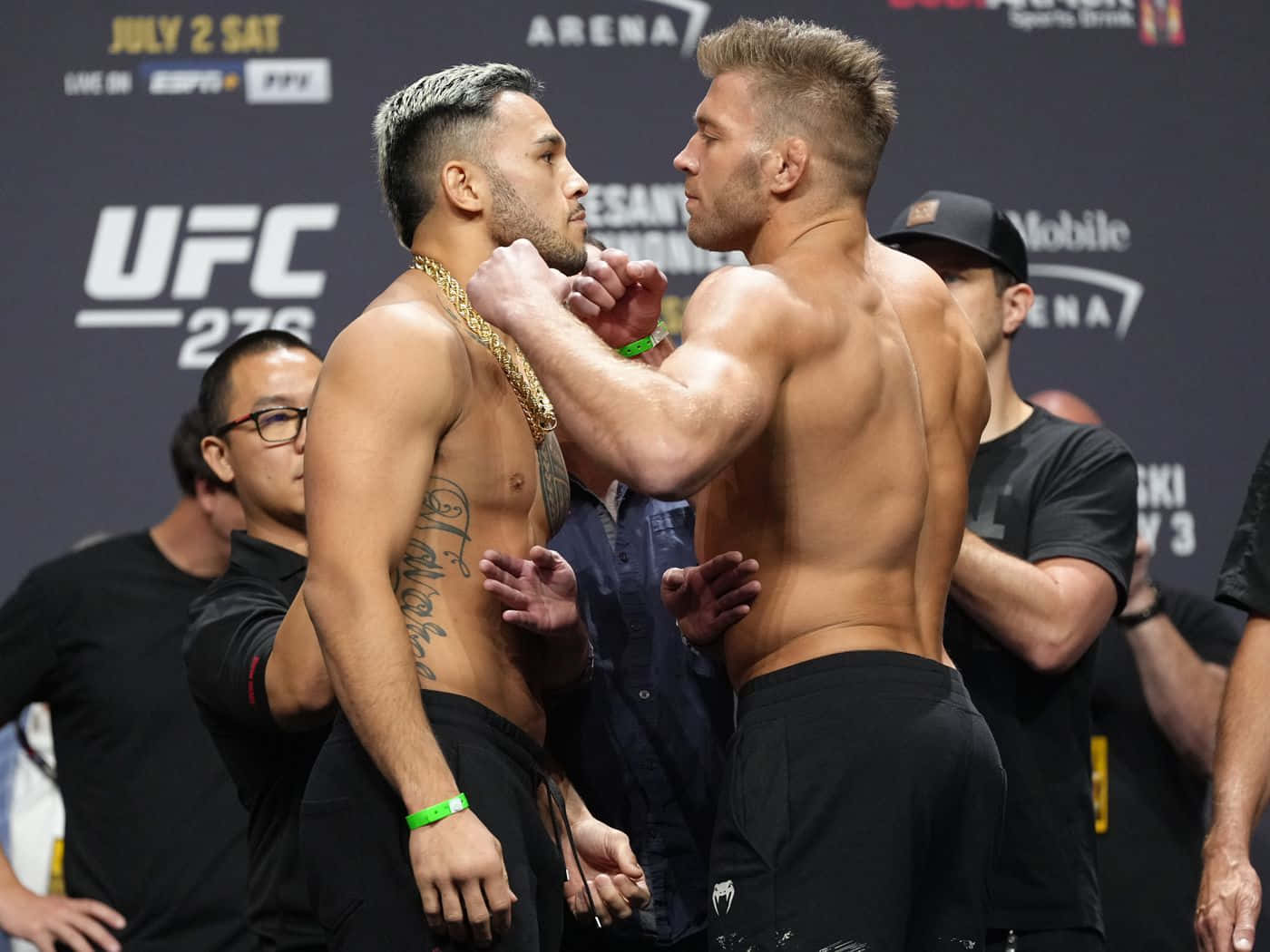 德里庫斯·杜普雷西斯與對手對峙 壁紙 — 兩名肌肉發達的UFC拳手在稱重活動中激烈對峙，冠軍金鏈和紋身清晰可見。