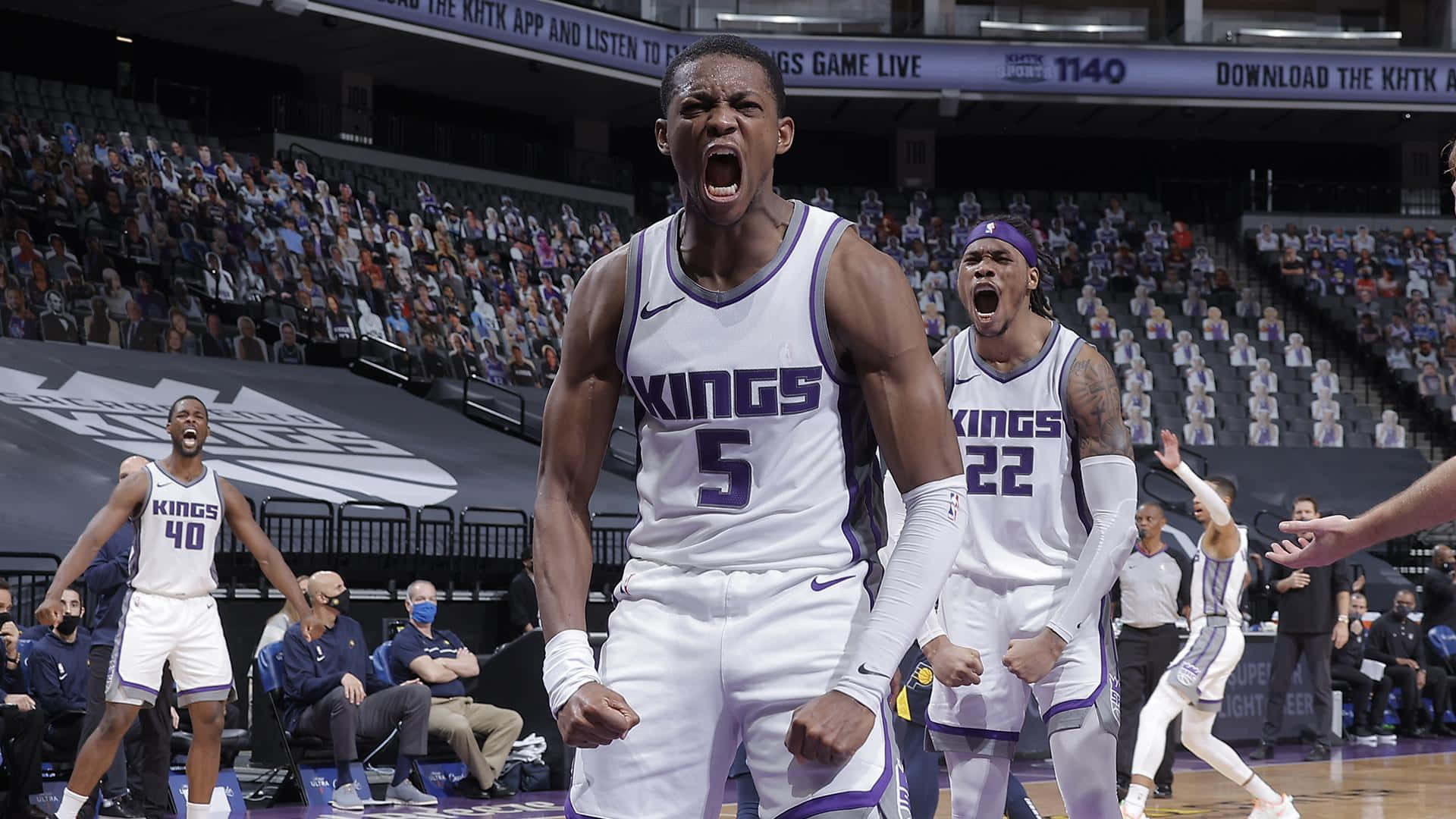 身穿Kings球衣的籃球運動員在擠滿觀眾的球場上慶祝勝利。