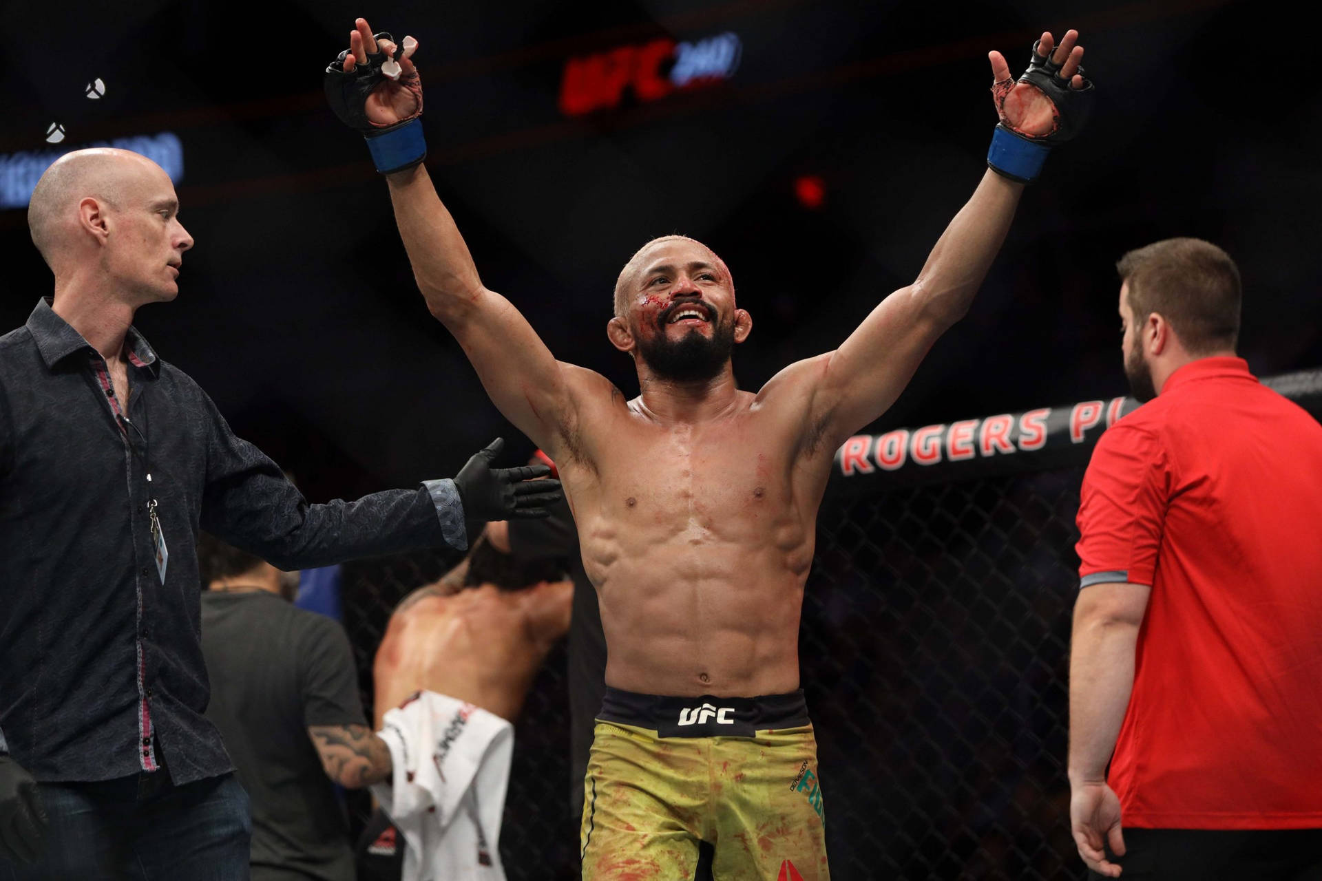 UFC拳手在八角籠內高舉雙臂慶祝勝利。
