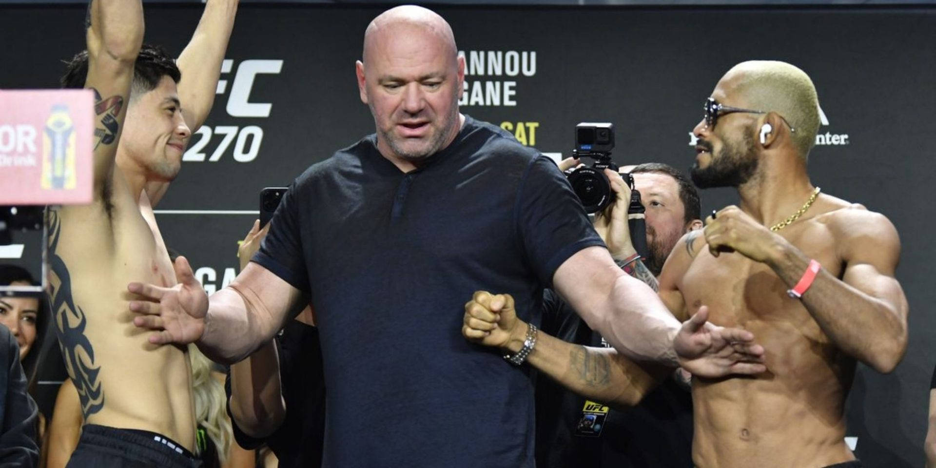 兩名UFC拳手在稱重活動中與相機一起夾著Dana White。