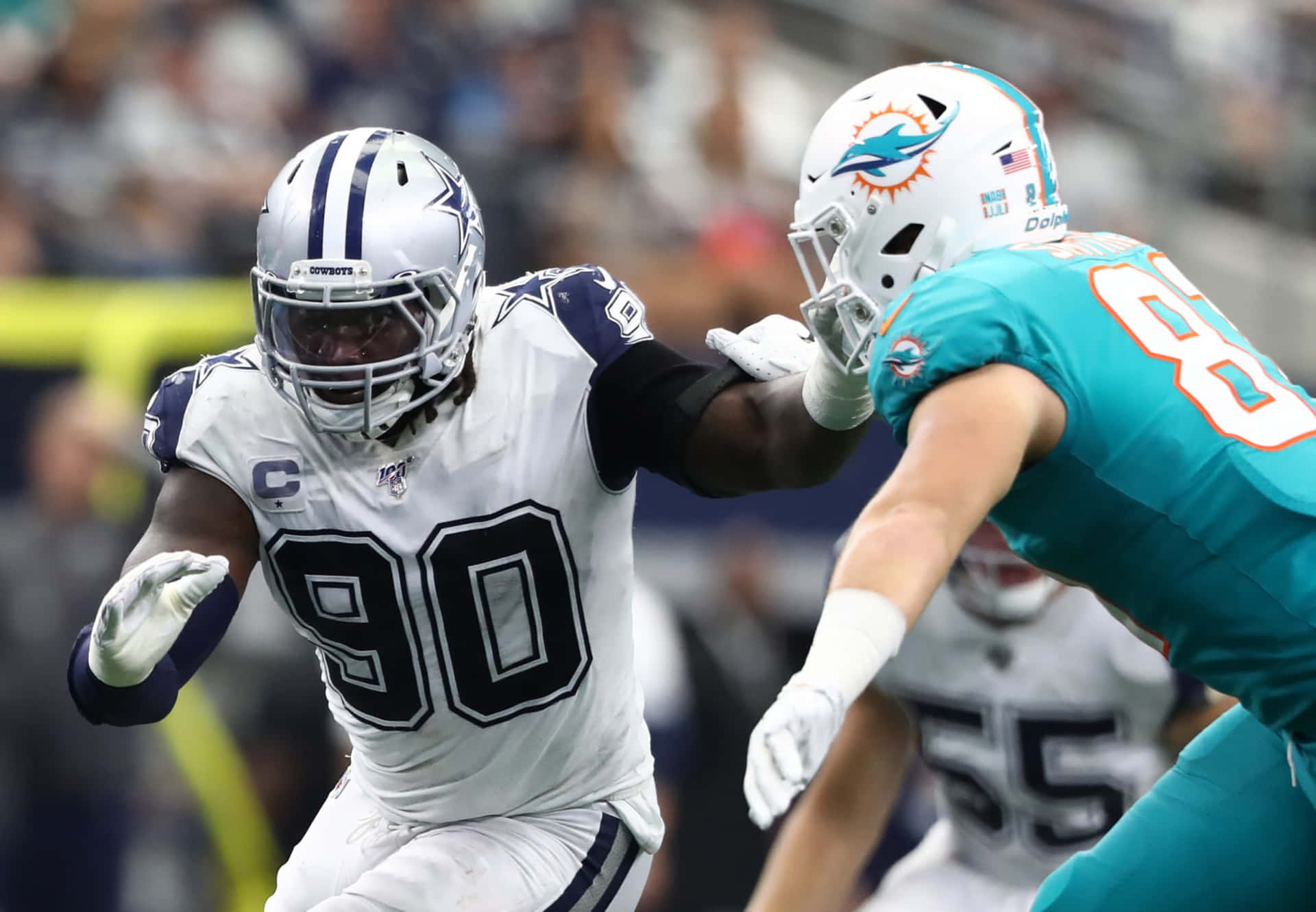 達拉斯牛仔隊防守端鋒在NFL比賽中擒抱邁阿密海豚隊球員。