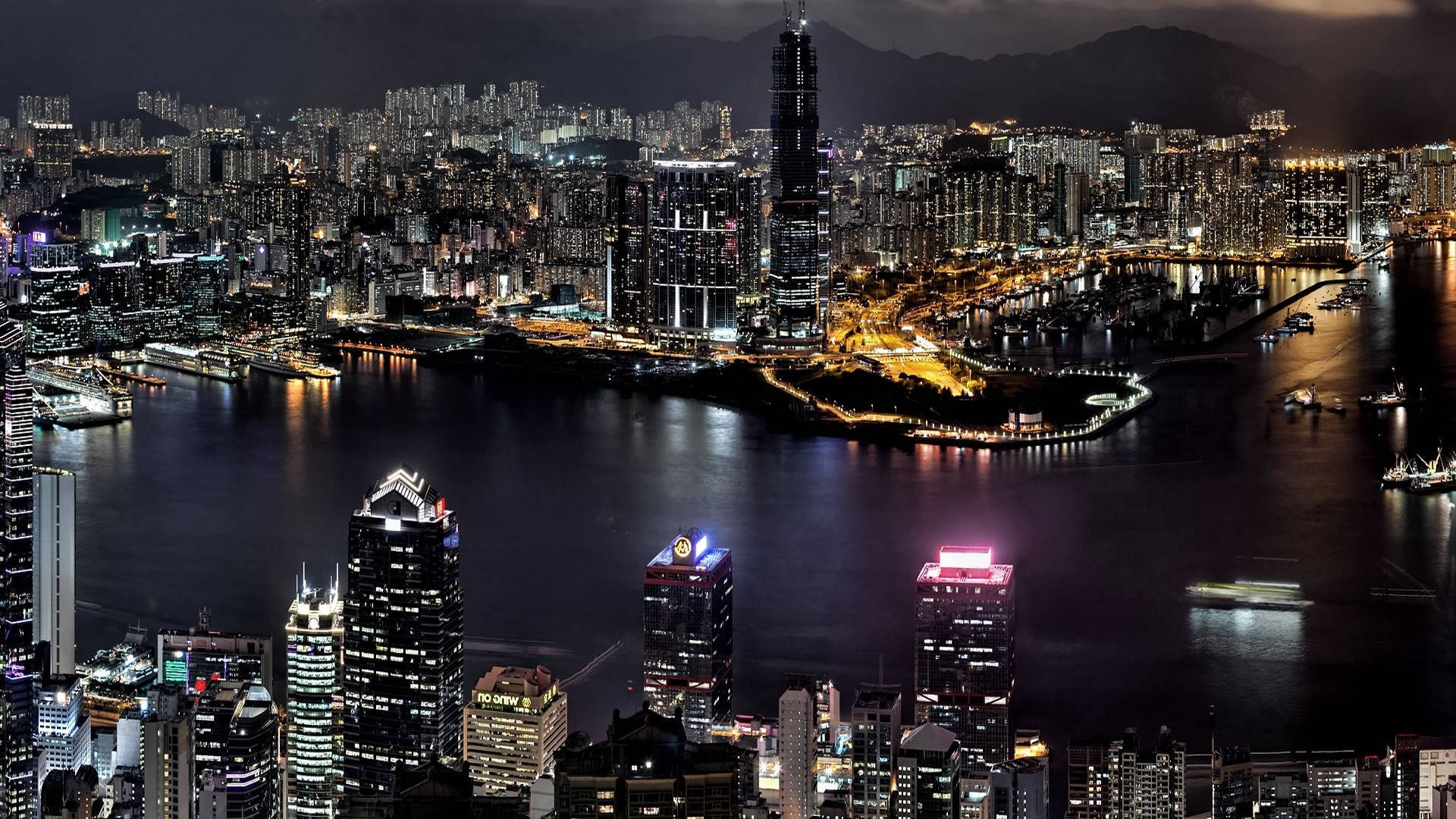 德黑蘭城市港口 壁紙 — 香港令人目眩神迷的夜景，閃爍的摩天大樓倒映在港口水面上。
