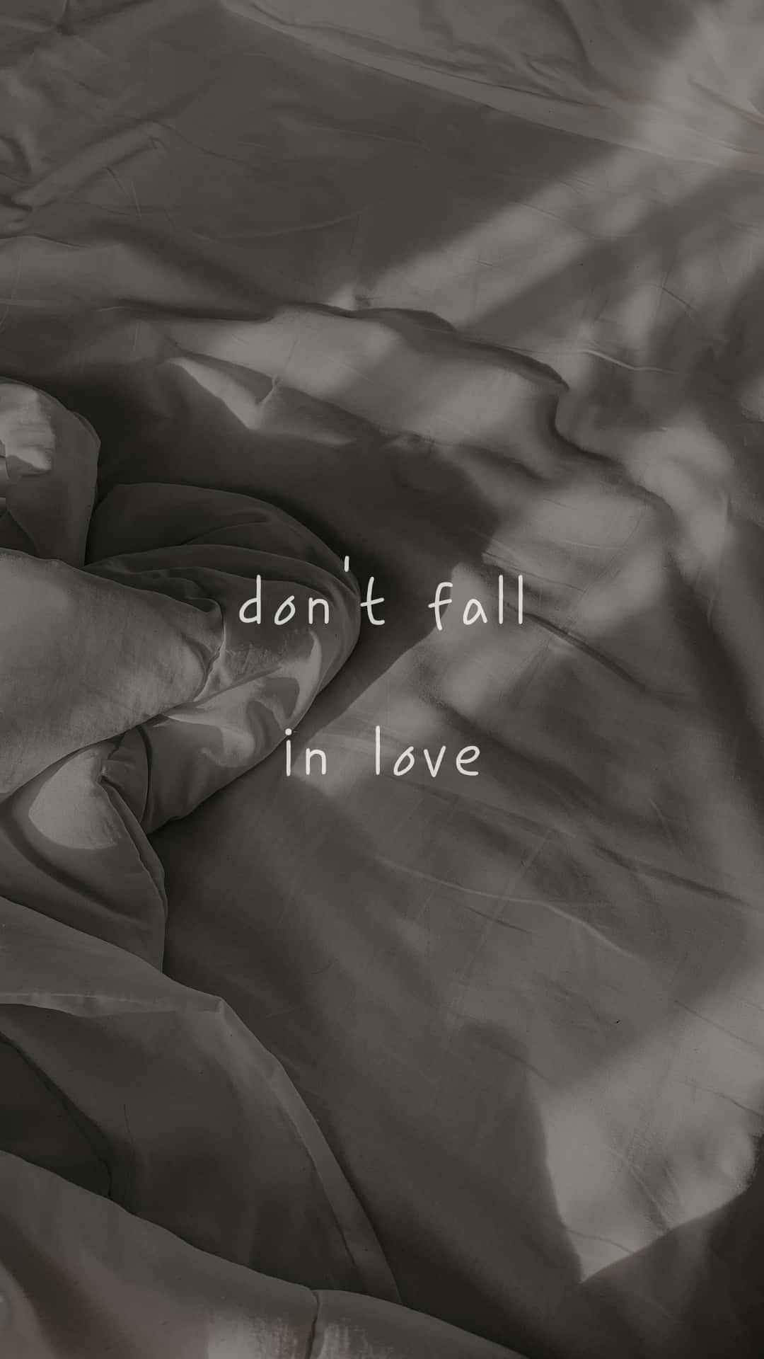 皺巴巴的灰色布料上的文字疊加顯示 don't fall in love。