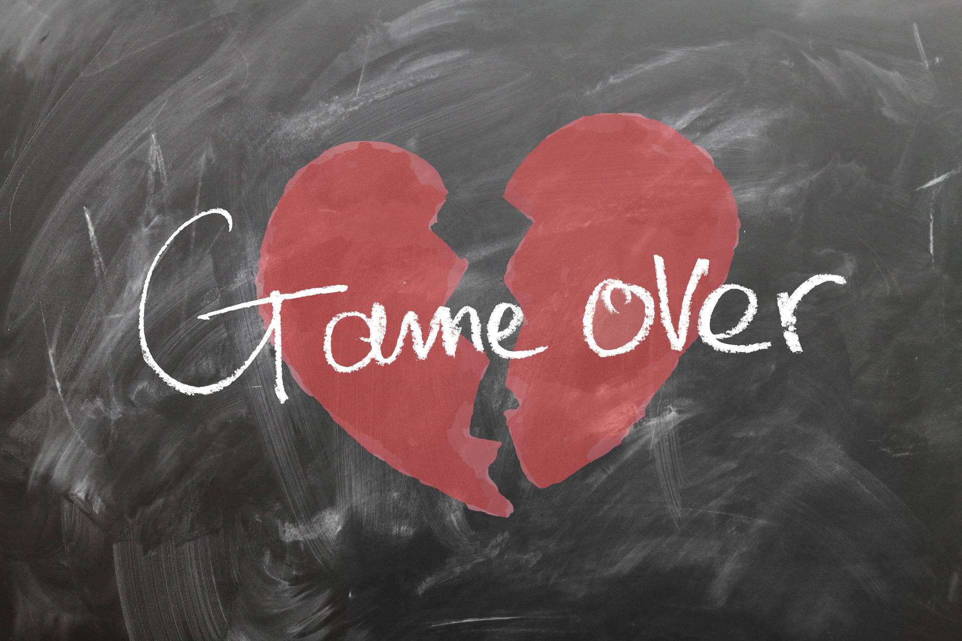 破碎的紅色心形，黑板上用粉筆寫著「game over」。