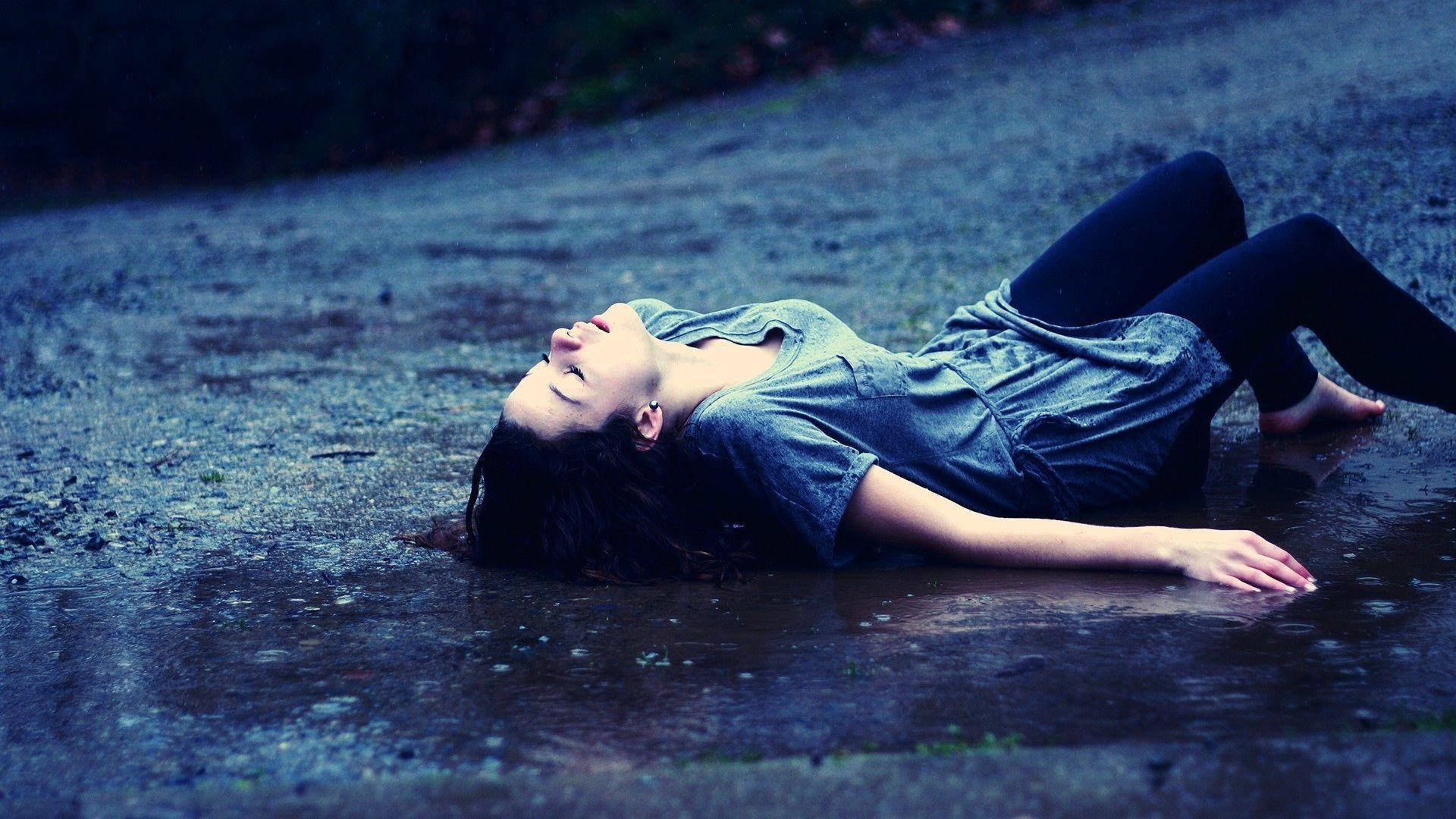 女子在濕路上的雨坑中閉眼放鬆。
