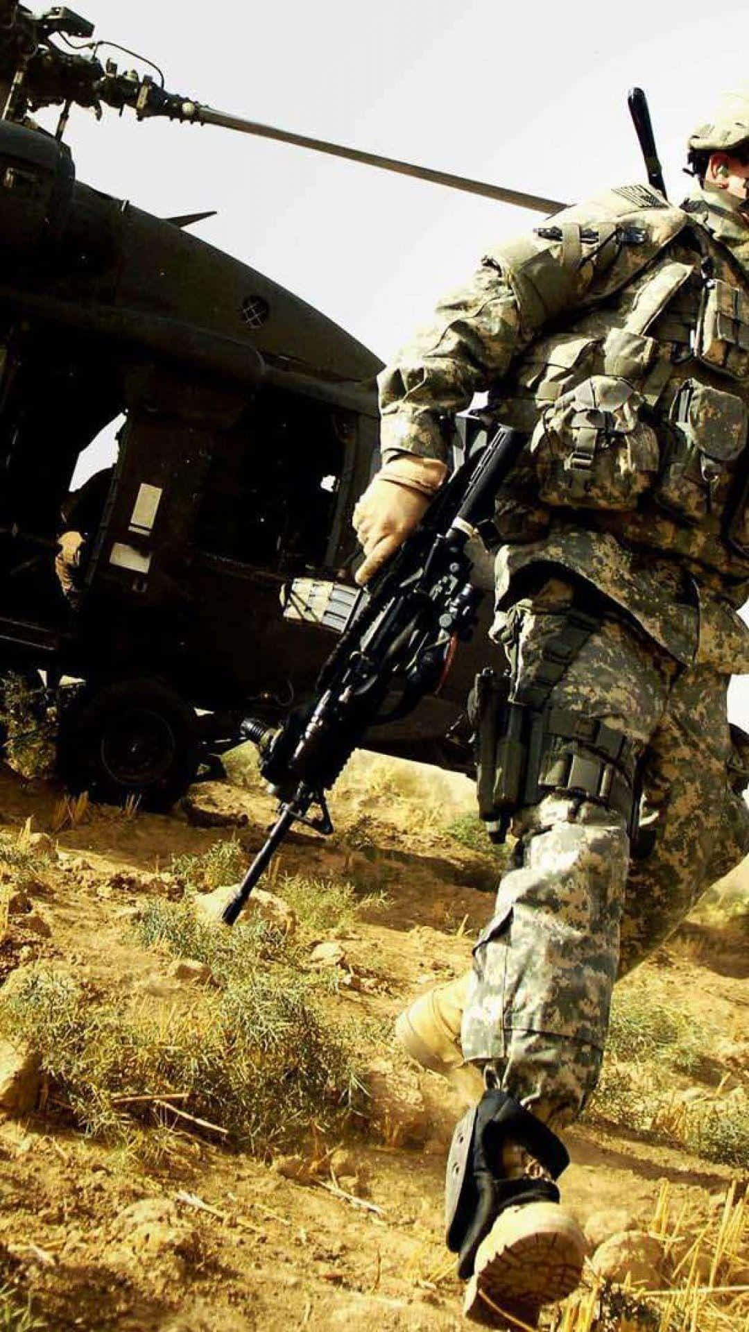 沙漠中持步槍靠近軍用直升機的士兵