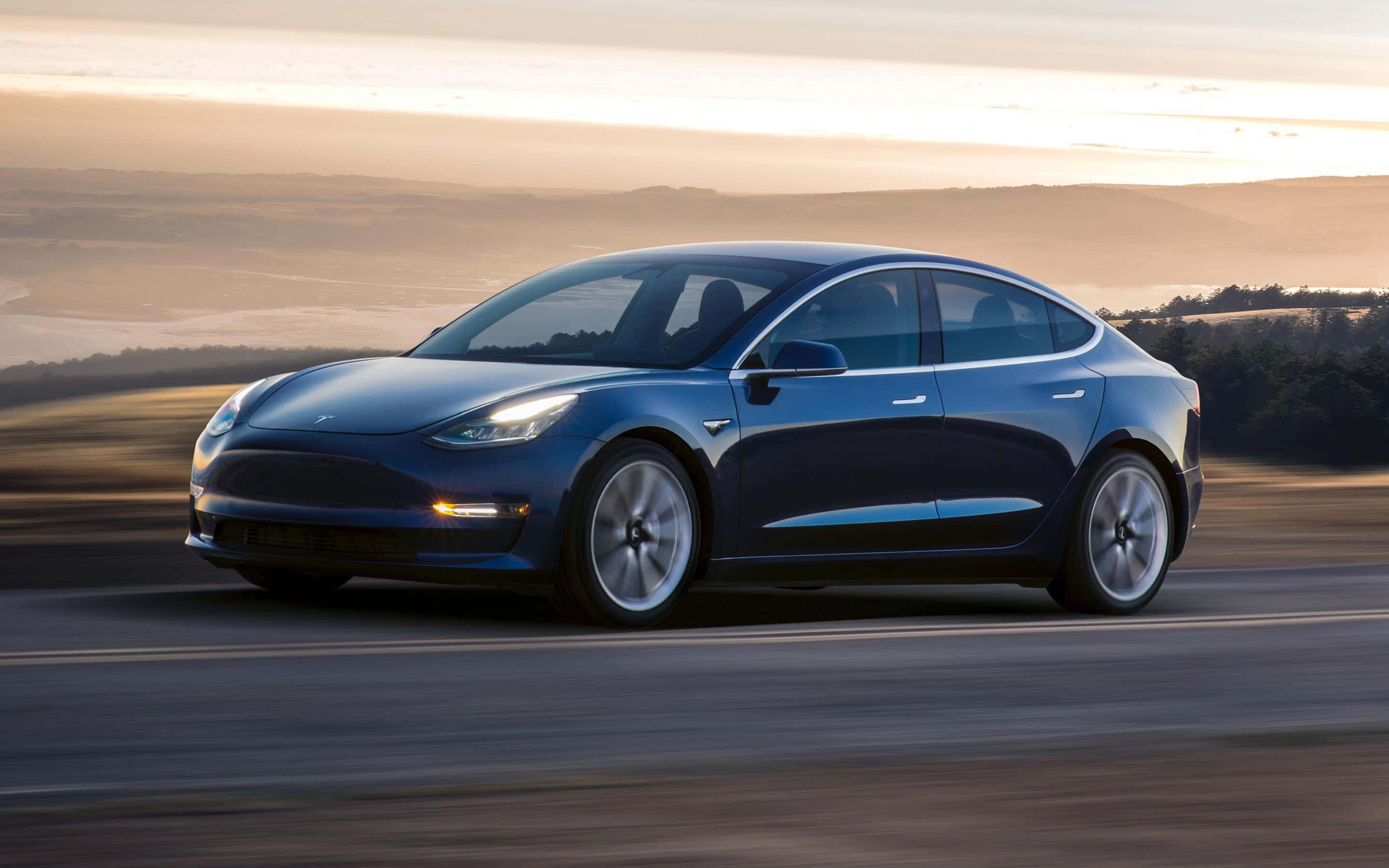 快來看看這款驚人的特斯拉Model 3！ 壁紙 — 一架流線型藍色Tesla Model 3在黃金時段沿著蜿蜒的道路行駛，背景是模糊的山丘。
