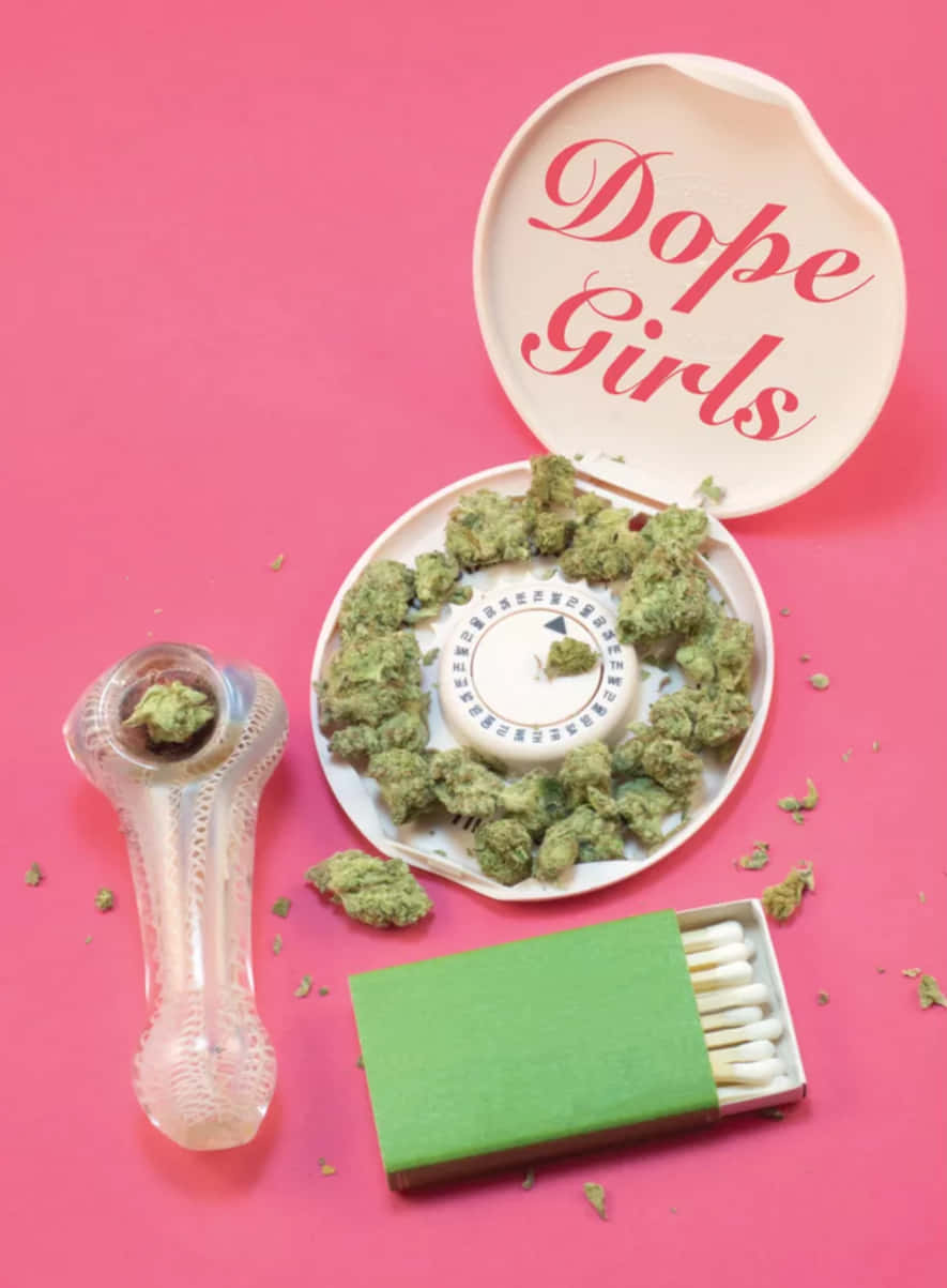 白色容器上寫有「Dope Girls」字樣，周圍環繞著大麻花蕾、玻璃水煙槍和綠色火柴盒，背景為粉紅色。