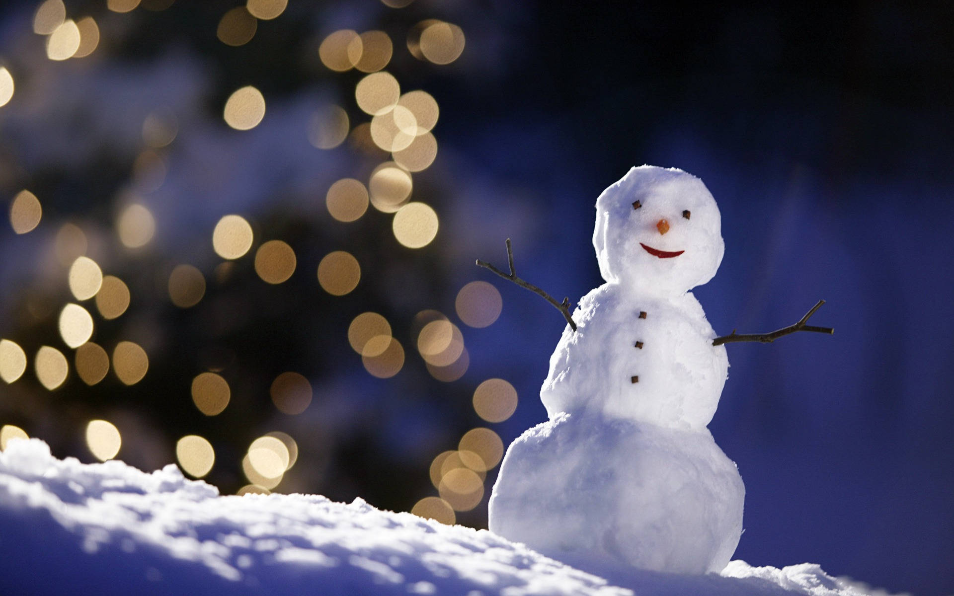 快樂雪人 壁紙 — 一個快樂的雪人，有樹枝手臂和胡蘿蔔鼻子，站在雪地裡，背景是閃爍的金色散景燈光。